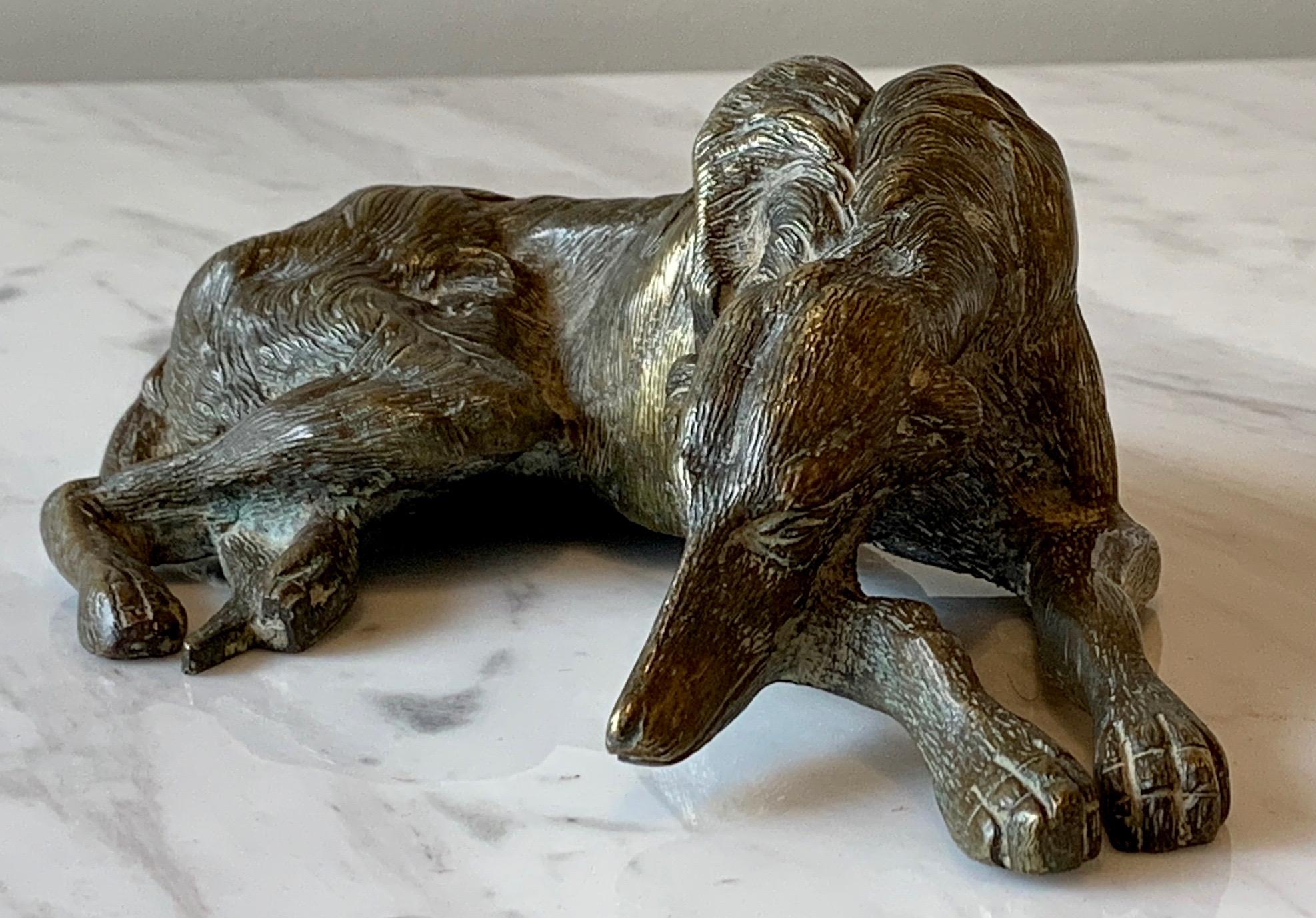 A beautifully patinated cast bronze sculpture of a recumbent wolfhound dating from the early 20th century.