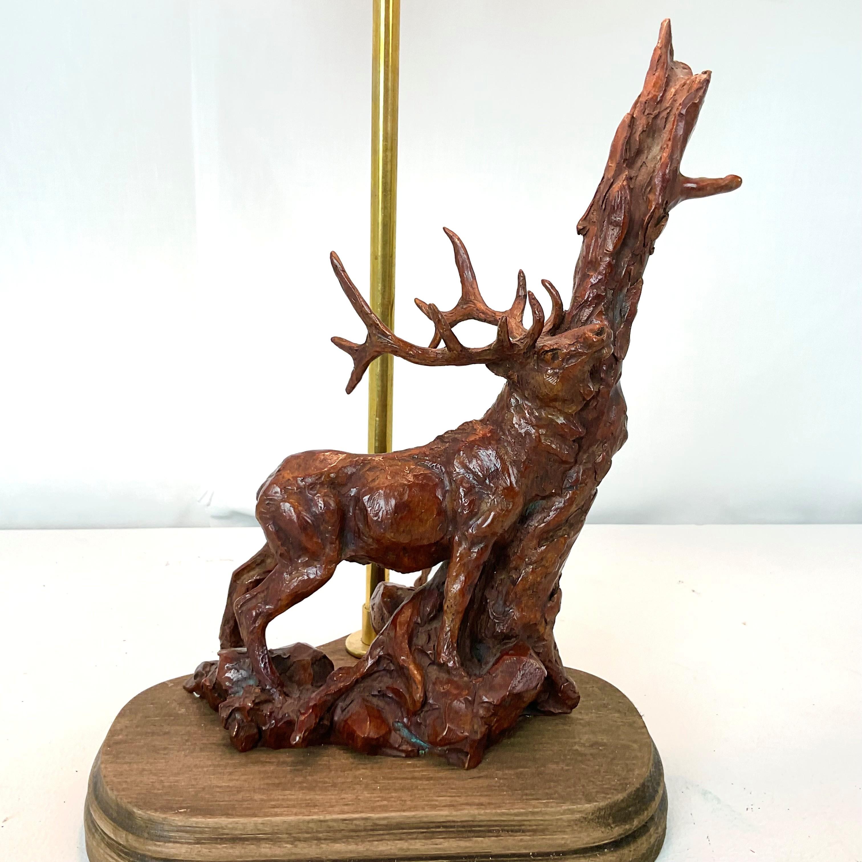 Bring a touch of nature-inspired elegance to your home with this unique table lamp featuring a hand-carved stag sculpture base. Crafted with remarkable detail, the stag is shown in a powerful stance against a tree, finished in a rich, deep wood tone