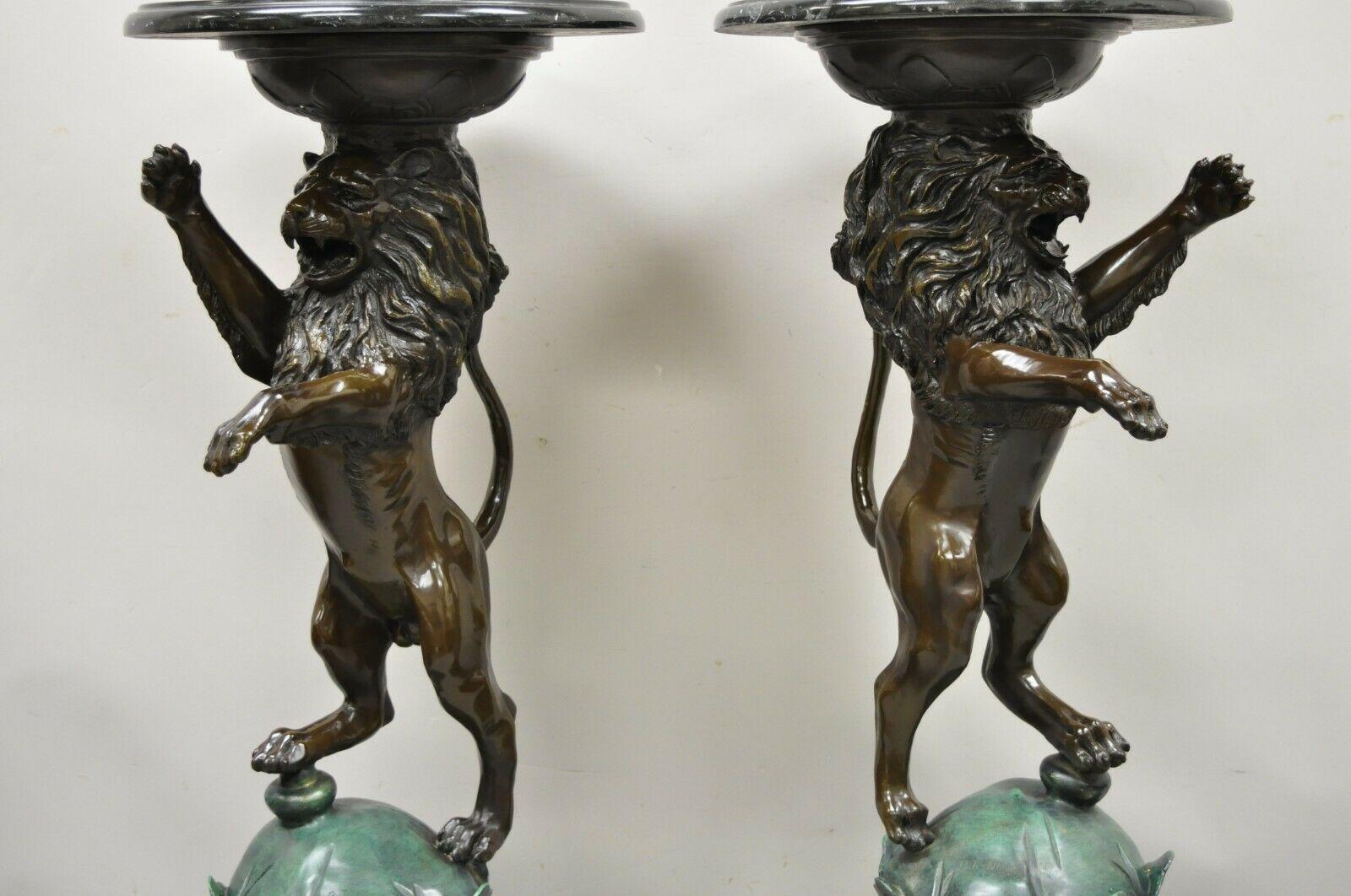 Cast bronze figural lion sculpture marble top pedestals after P.J Mene - a Pair. Item features right and left forms, heavy cast bronze lion figures, round black marble tops, signed 