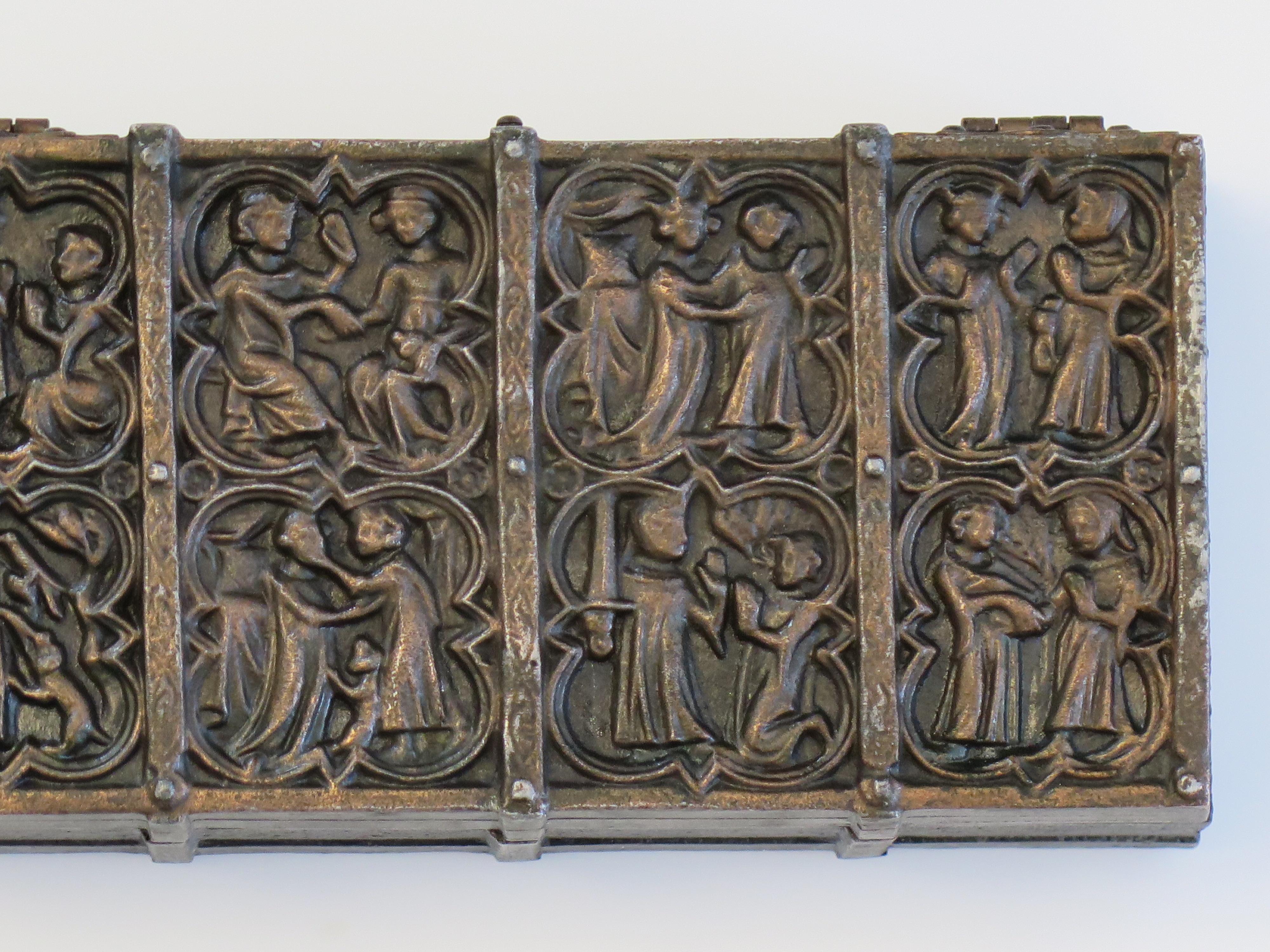This is a cast bronze metal box modelled as a casket with a wood liner and  depicting medieval scenes. We date this box to the late 19th Century. 

The box is made of a cast metal (bronze) shaped in the form of a rectangular casket with small feet