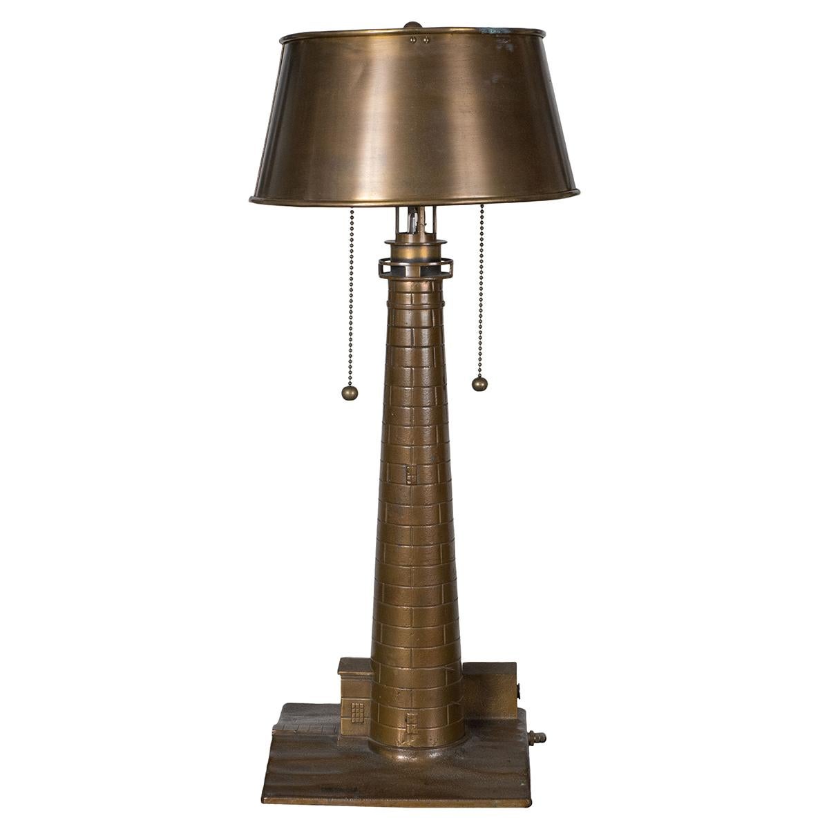 Cast bronze lighthouse table lamp with original metal shade. Features pull chain switches and base switch that controls a smaller central light.