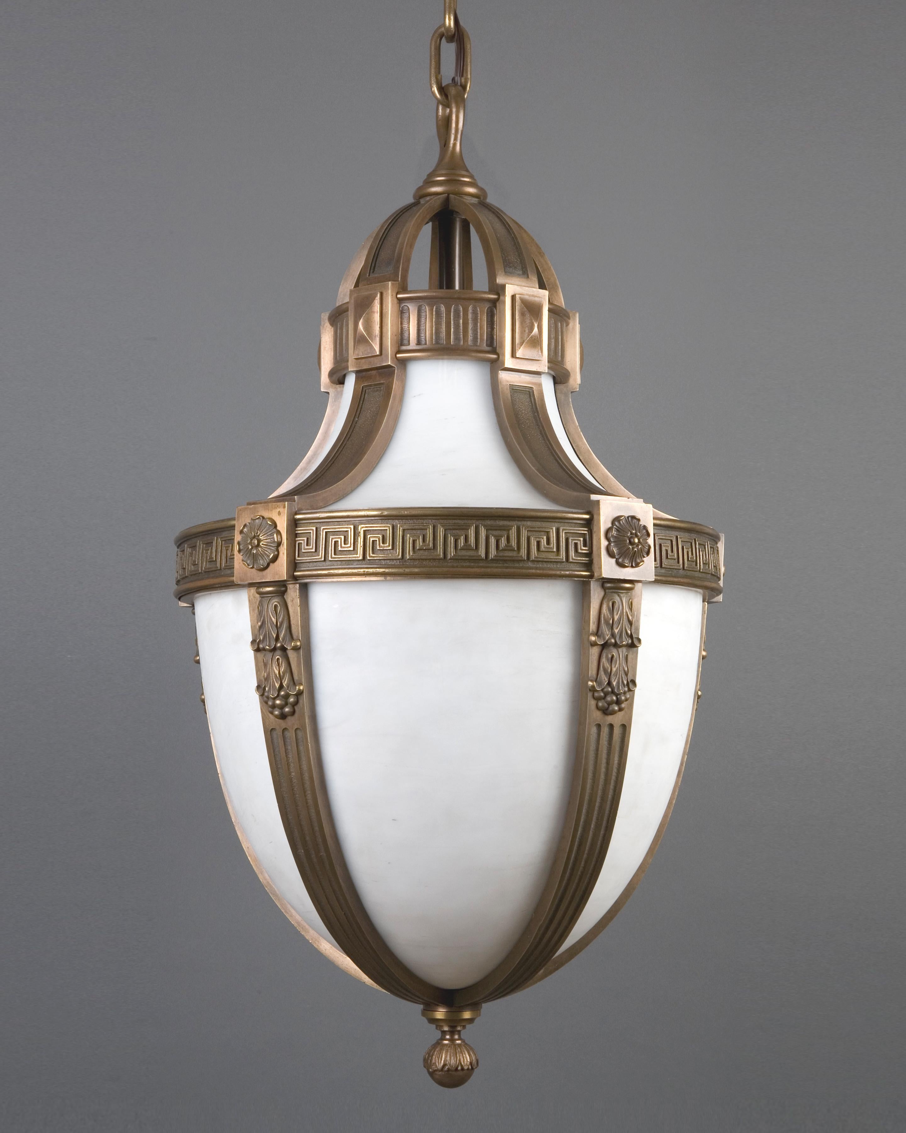AHL3079

A large Neoclassical pendant lantern having opalescent white art glass panels set in an age-darkened cast bronze frame with a Greek key and bellflower motif. Circa 1900. Due to the antique nature of this fixture, there may be some nicks or