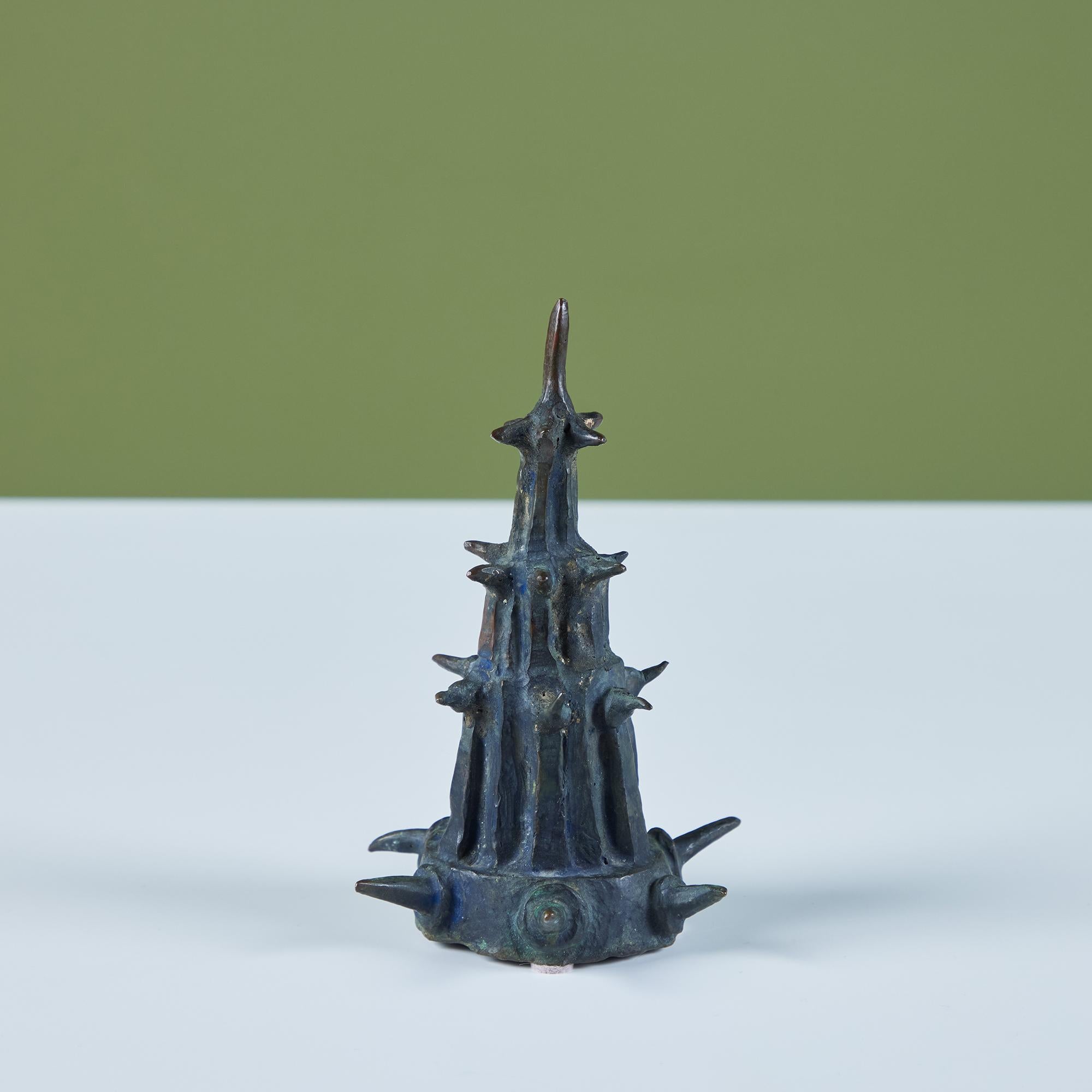 Cast bronze sculpture by American sculptor J. Dale M'Hall featuring a cone tower with protruding spikes all over. James began sculpting in the 1960's and has worked with a variety of different media throughout his career but bronze sculpting is his