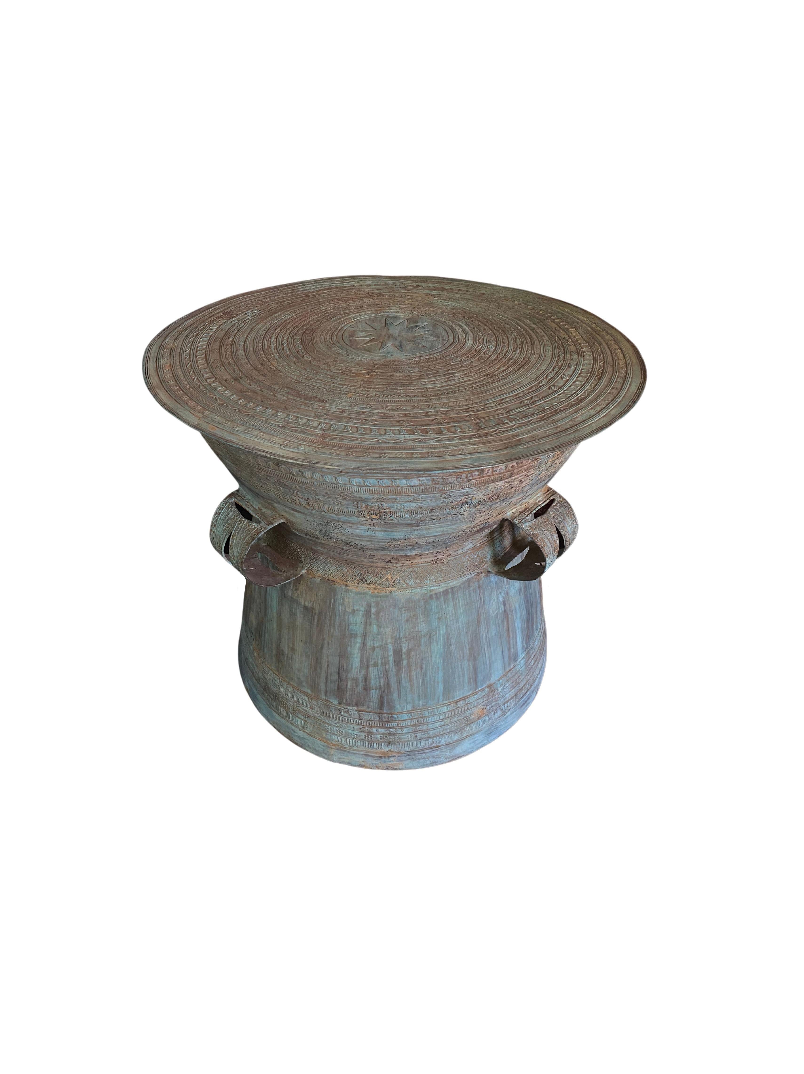 This cast iron bronze drum is inspired by the rain drums of South East Asia, particular those found in Burma, Laos and some of the Eastern Islands of Indonesia. This drum features three engraved handles. There are elaborate engravings on its sides