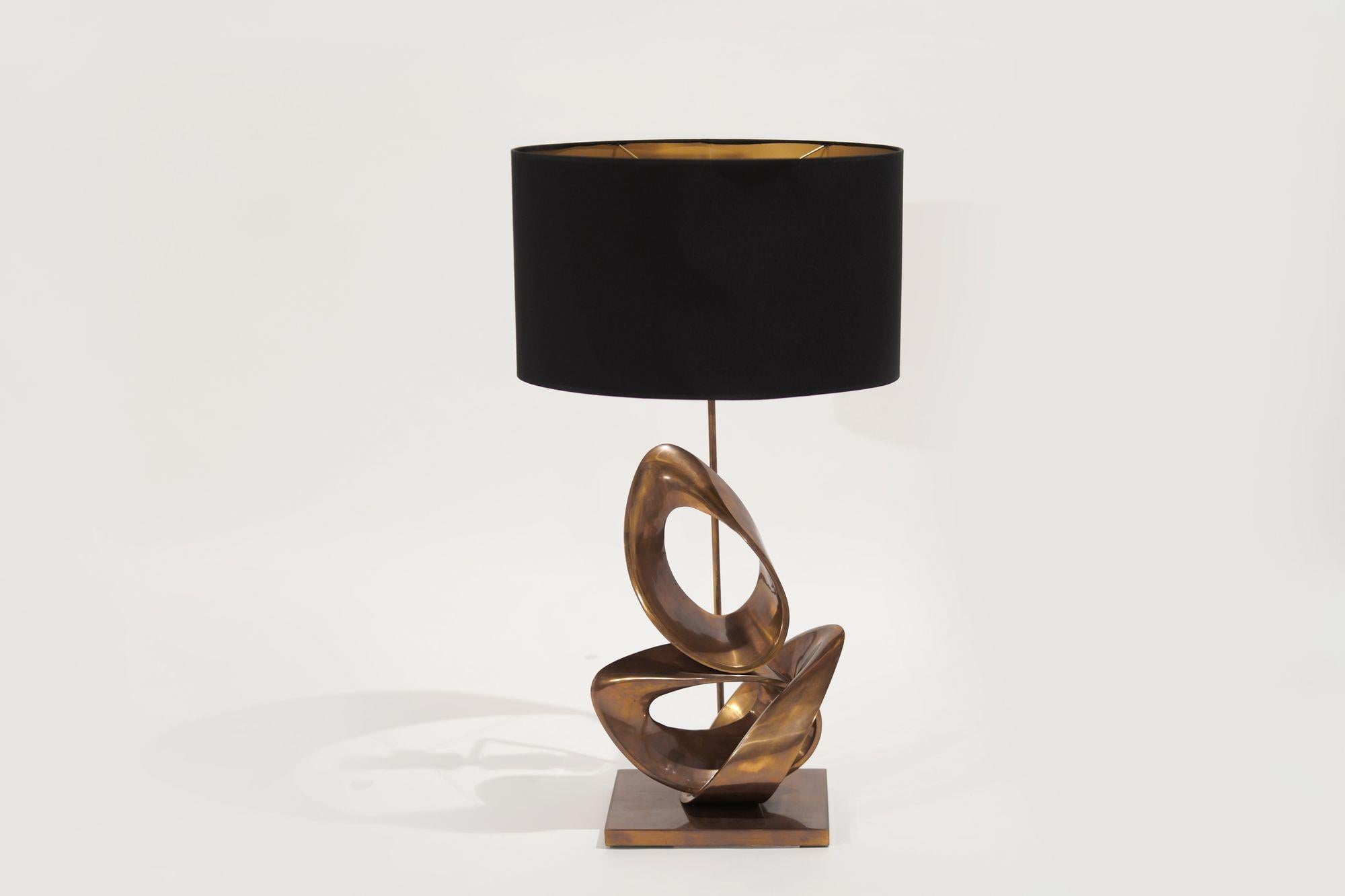 Is it and sculpture or a table lamp? How about both? This beautiful table lamp designed by the incredibly talented Nur Birol, features very thoughtful organic lines and a warm bronze hue. The shade is lined with gold leaf on the inside, and black