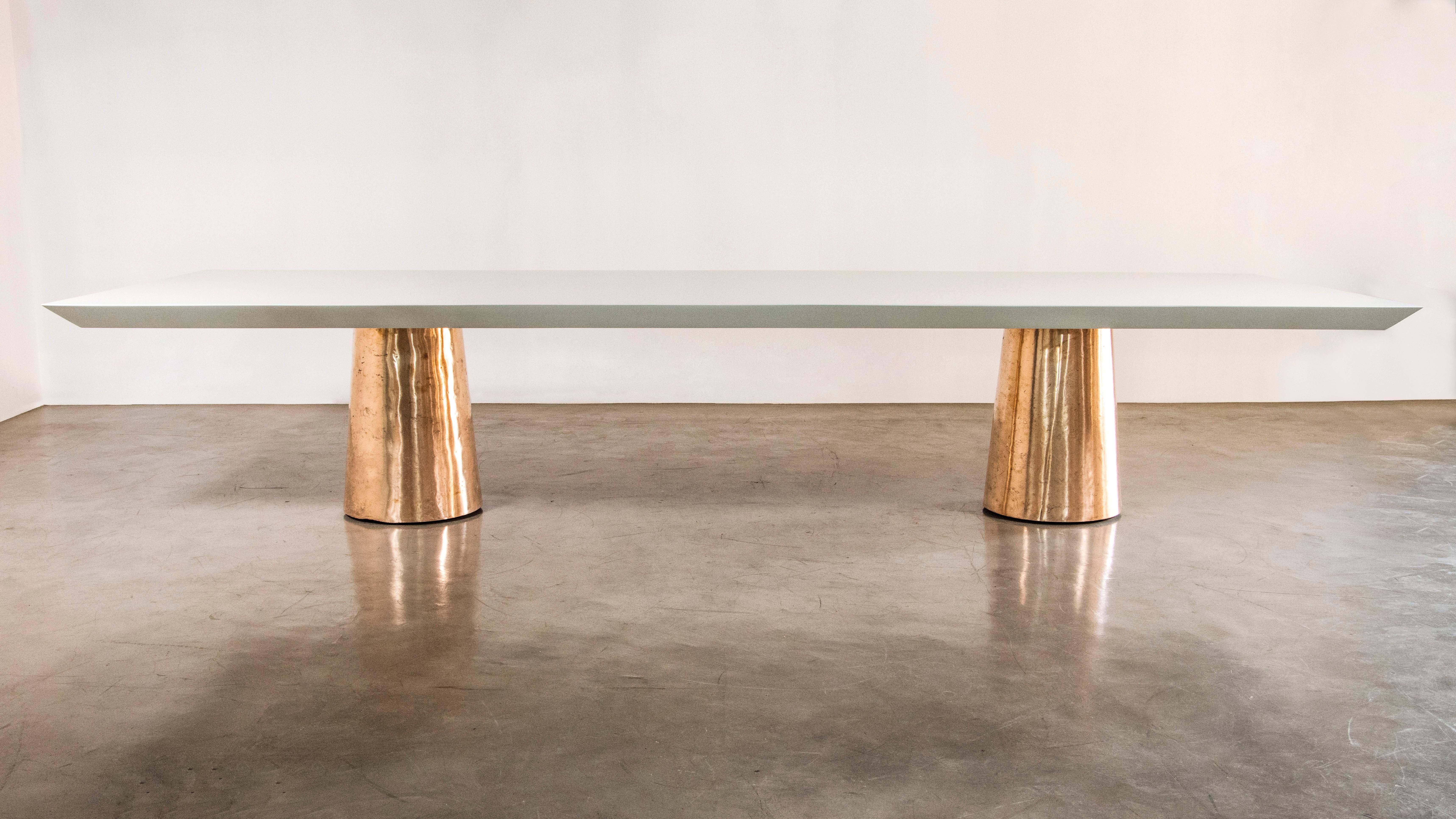 Der Tisch Benino besteht aus zwei polierten Bronzegussfüßen und einer lackierten Holzplatte mit Messerkante.  Erhältlich auch mit Stein- oder Naturholzplatte, in jeder Größe und Ausführung.  

Die Maße sind: 156