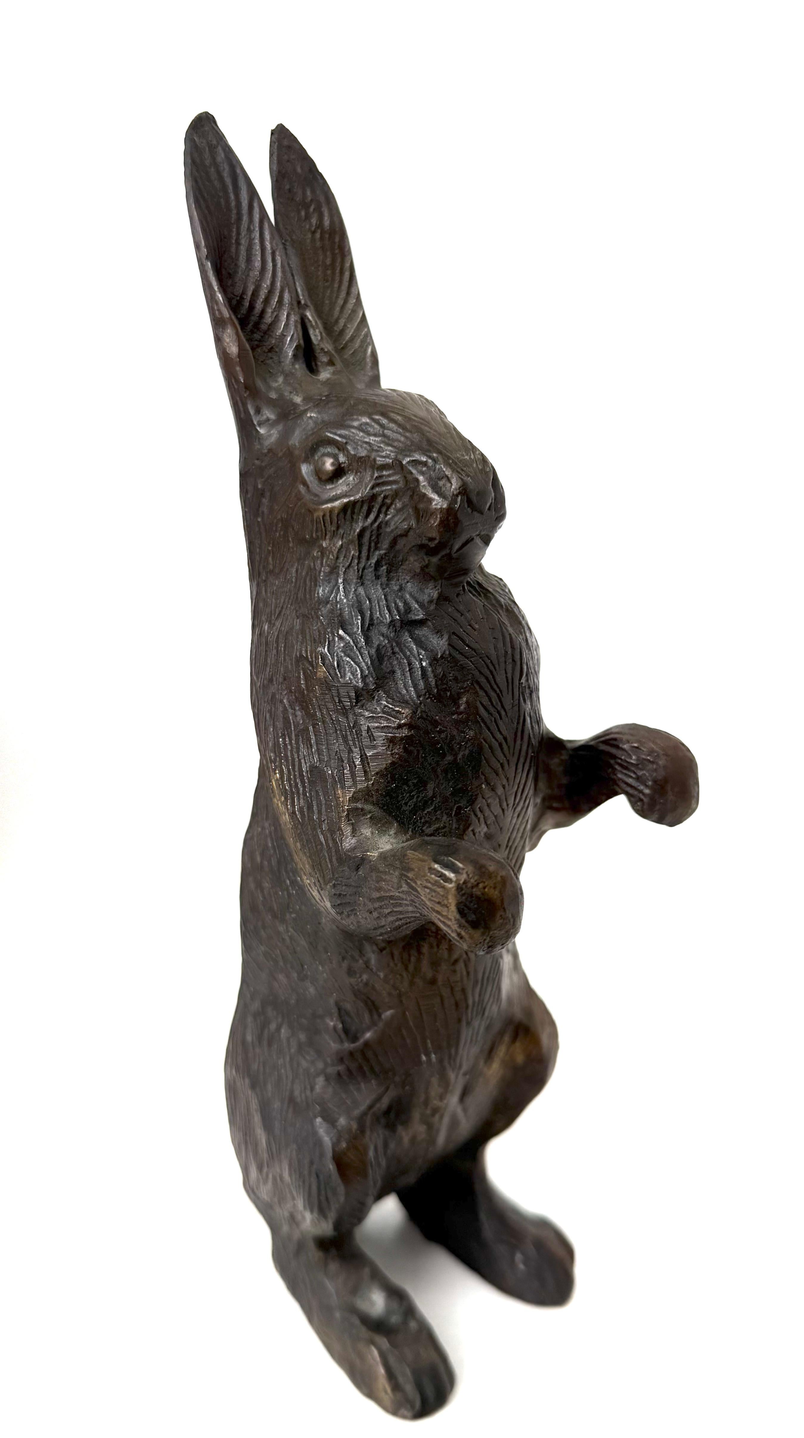 Decorative garden ornament in cast bronze consisting of finely detailed rabbit in typical characteristics: upright posture on hind legs with outstretched arms and propped up ears, fine hair and facial expressions. In addition to garden decor this