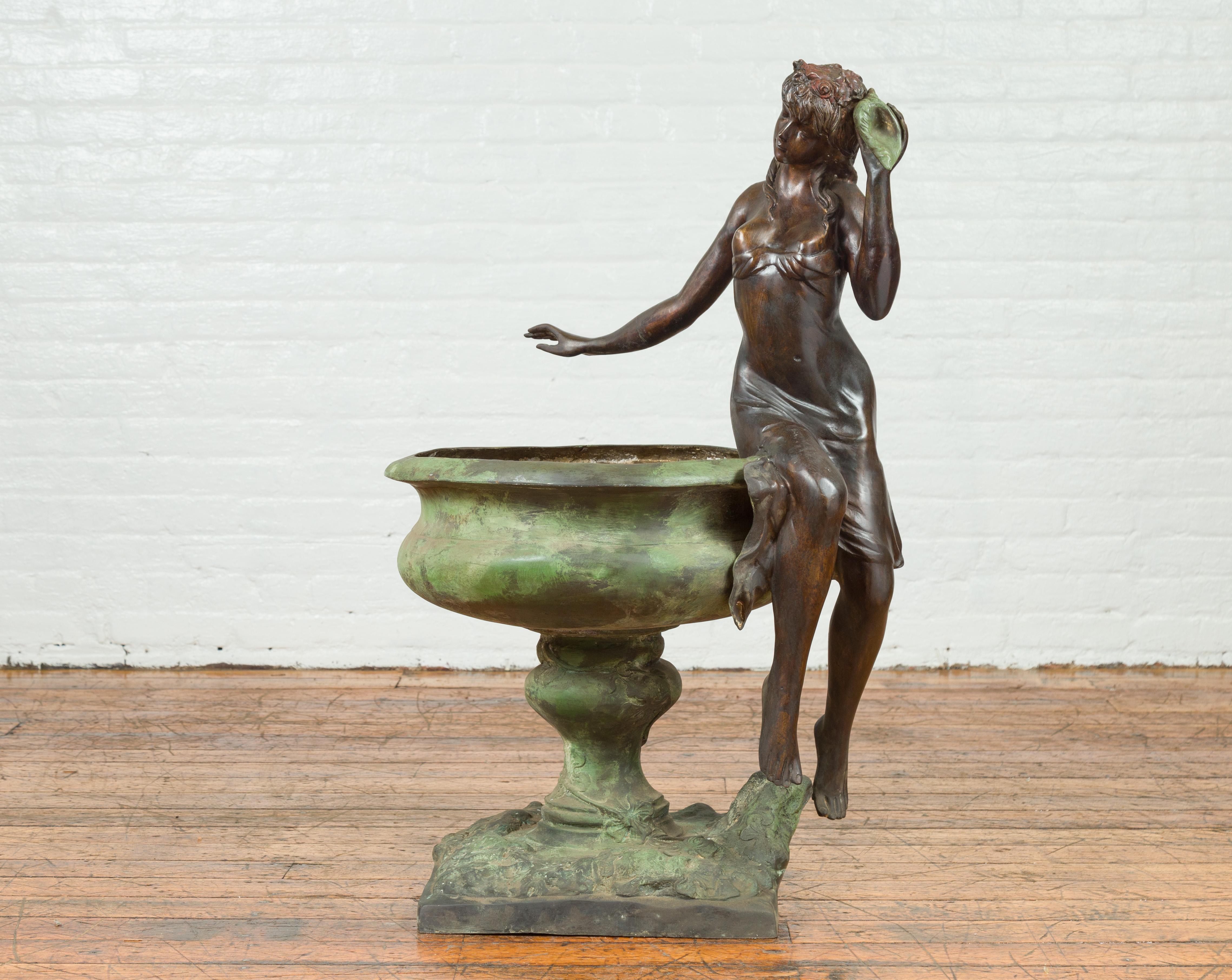 A vintage Verde bronze fountain from the mid-20th century, depicting a maiden holding a shell. Created with the traditional technique of the lost-wax (à la cire perdue) that allows a great precision in the details, this cast bronze fountain features