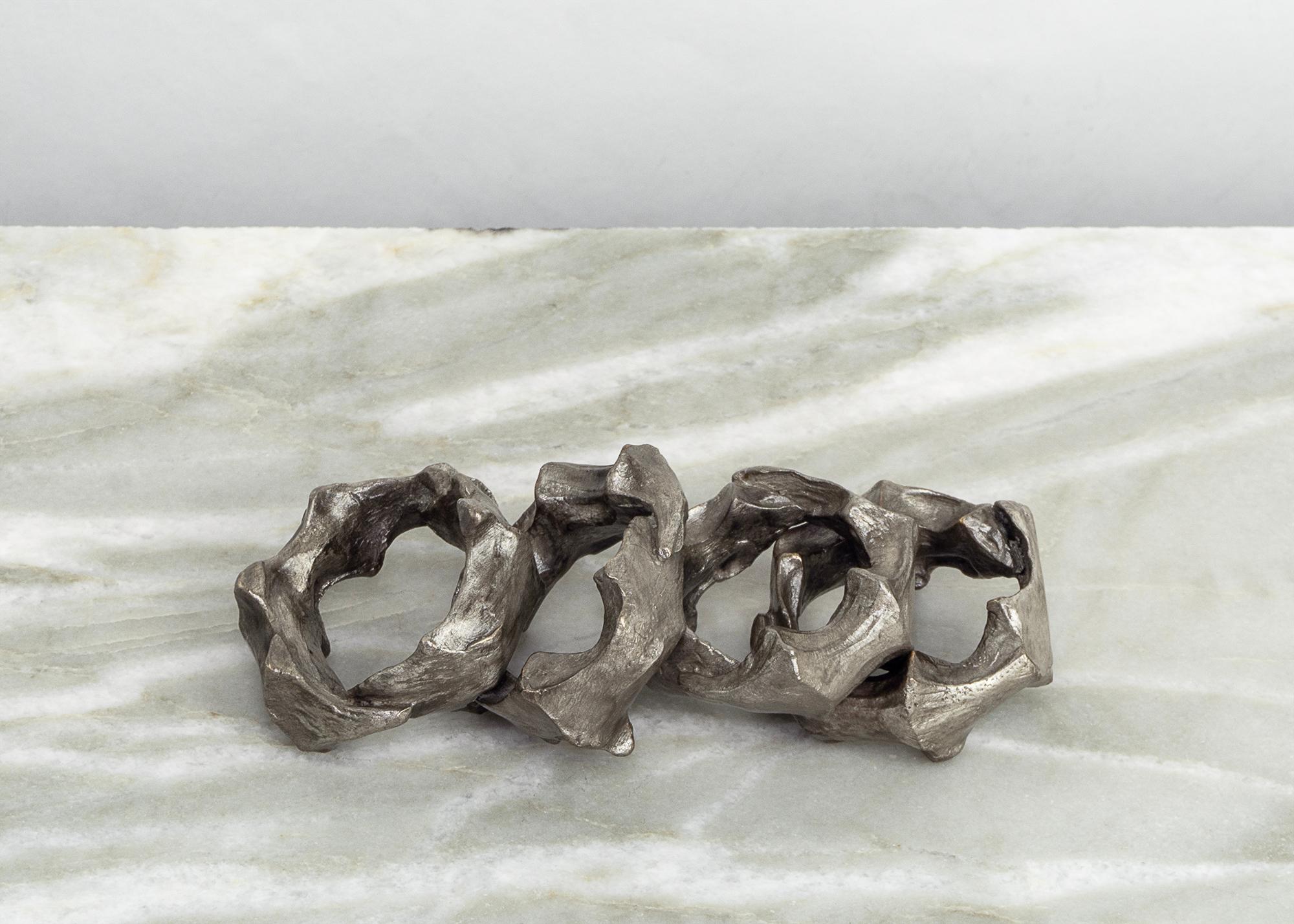 I portatovaglioli Di Mano dell'artista Tom Bollinger sono un mix sorprendente di arte e funzionalità, progettato per elevare l'esperienza culinaria. Ogni portatovagliolo è realizzato a mano in bronzo e rifinito con una patina di nitrato d'argento