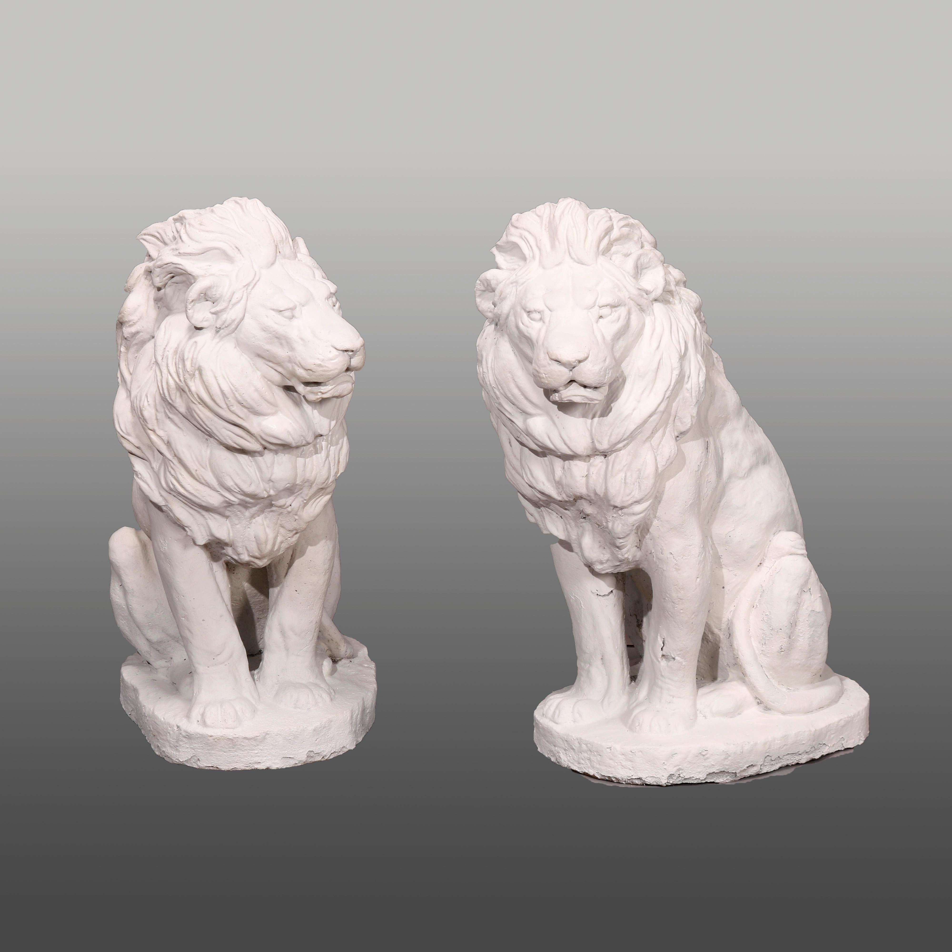 A pair of figural garden sculptures offer painted cast hard stone classical lions in the seated position, 20th century.

Measures- 26.75''H x 12.5''W x 21''D.

Catalogue Note: Ask about DISCOUNTED DELIVERY RATES available to most regions within