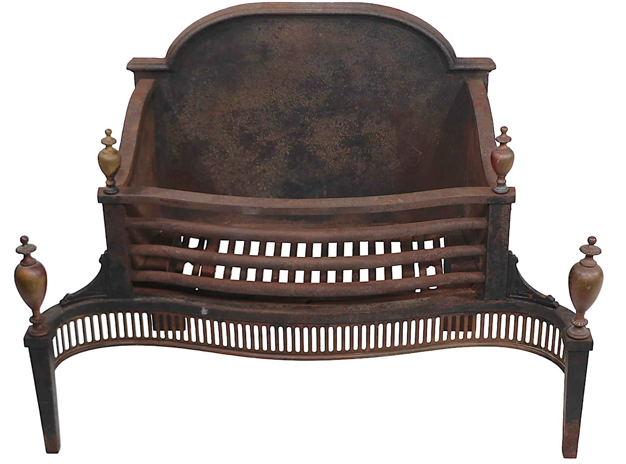 Very nice oversize coal insert grate constructed of cast iron, with decorative brass trim. The grate features a dome top backplate, a  coal, or wood basket, with a pierced brass concave front grill, with  brass legs and finials. This exceptional