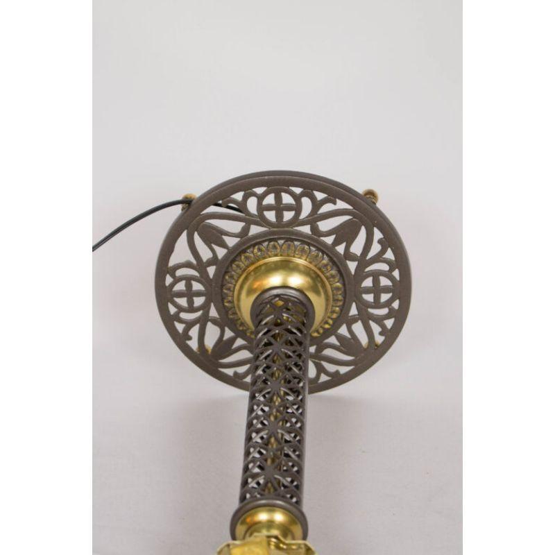 Cast iron and brass filigree lamp. May have been originally gas. completely restored, metals cleaned, polished brass and iron freshly painted in a dark bronze with gold detail. rewired. American, c. 1890

Dimensions: 
Height: 15″
Diameter: 7″