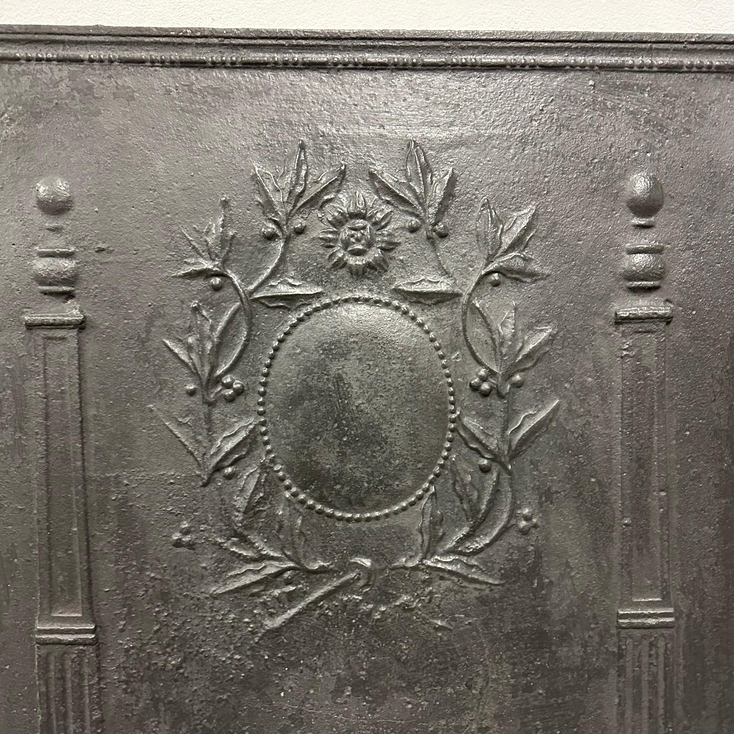 A nice square cast iron fireback / backsplash.
Two decorative pillars with lovely floral deorations in between.

Great piece!