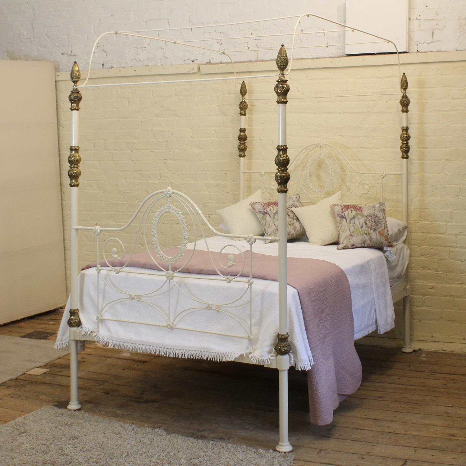 A 5ft wide cast iron antique four poster bed in cream with ornate castings and original brass decoration. The arch canopy can be replaced with a straight one if you wish, or even removed completely to create a tall post bed. Please enquire for