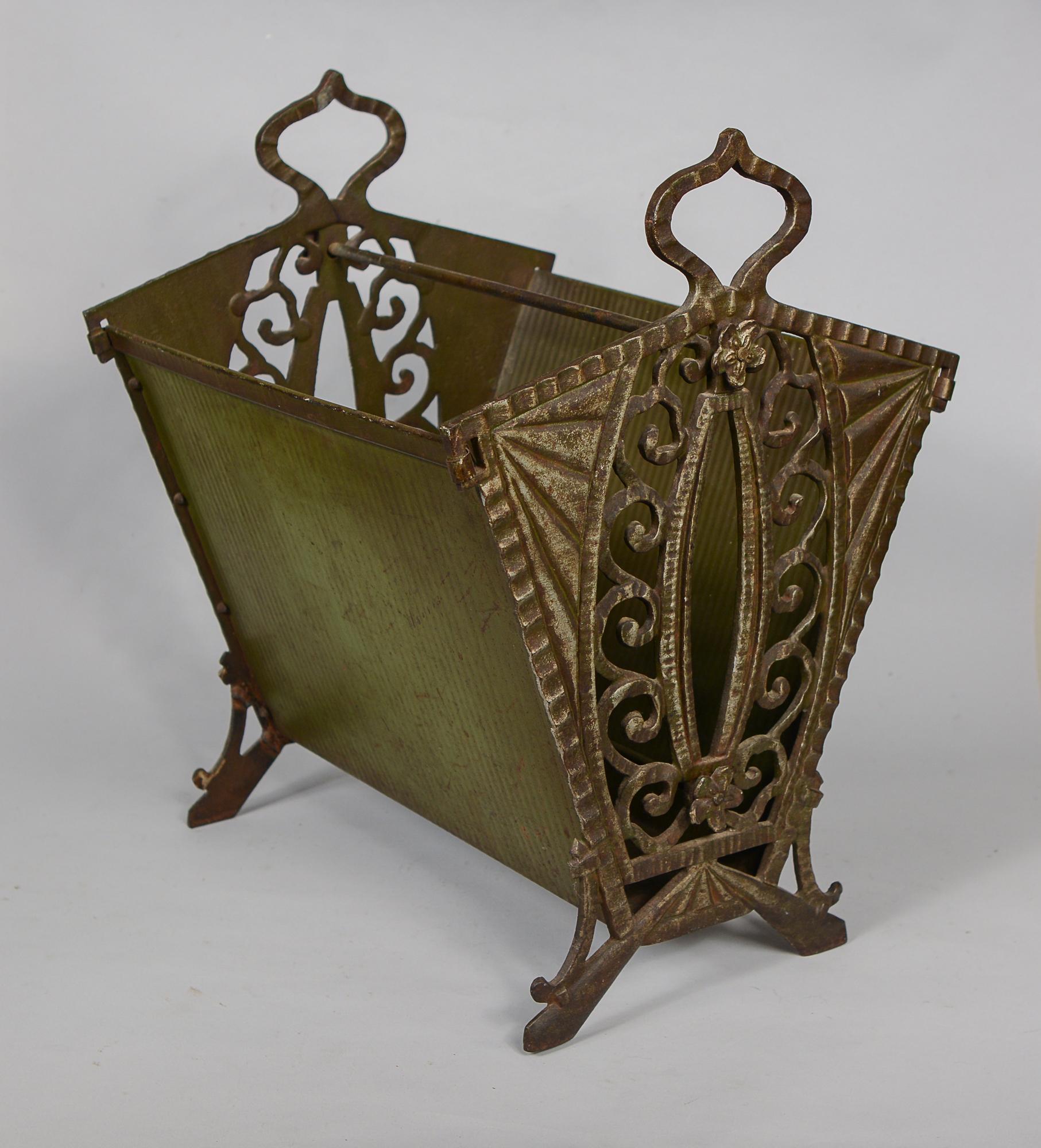 Cast iron art deco magazine rack made by Verona Steel Casting Co. This has ornate cast iron ends with sheet metal sides. The cast iron sides are marked Verona Pat. Pend. One leg has an older weld repair.