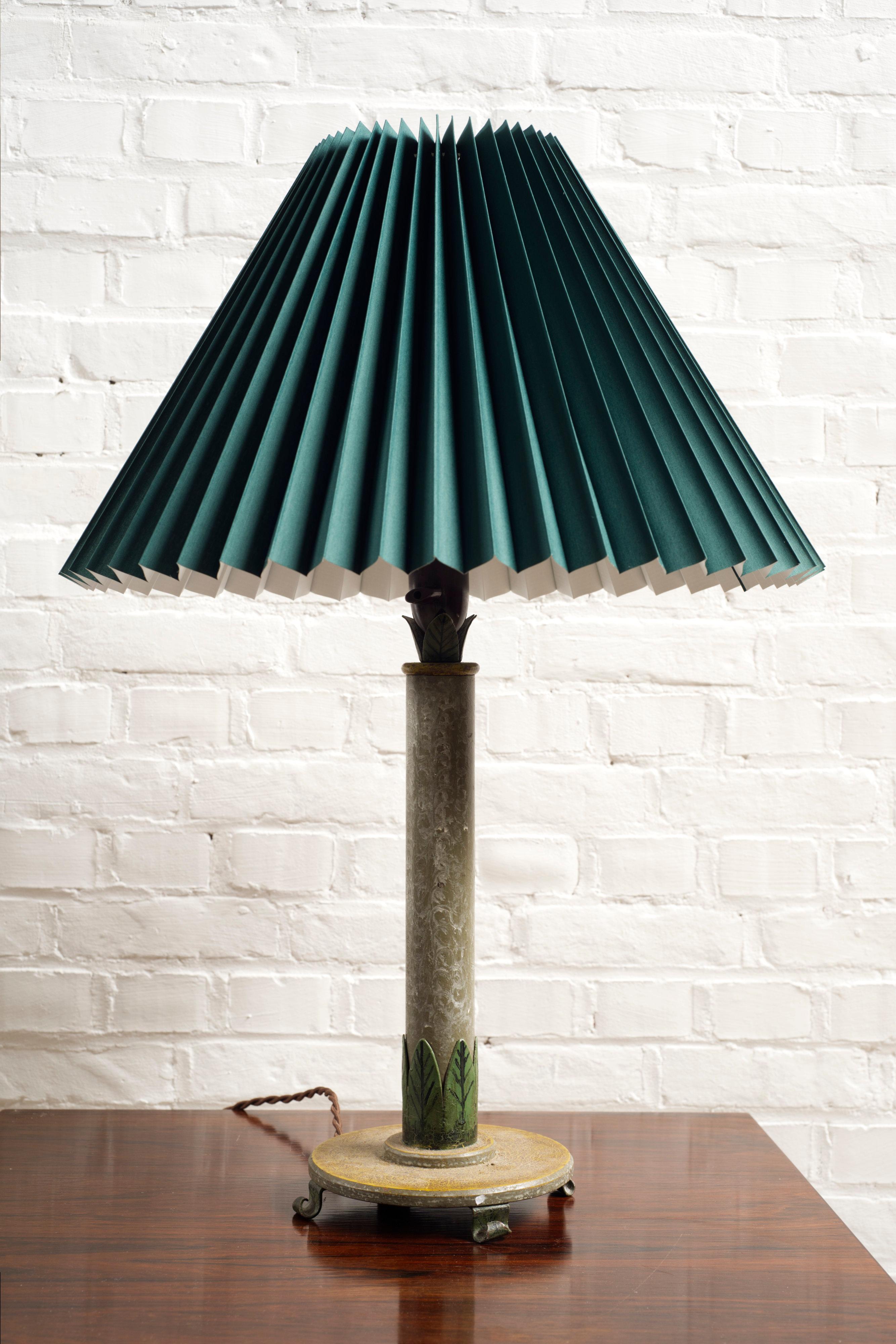 
A very unique cast iron table lamp with beautifully painted metal details. Handmade and painted leaf details and feet.

Inspired by art nouveau characteristic but understated in its elegance. 

Frame base 17cm wide, lampshade 44cm wide, height