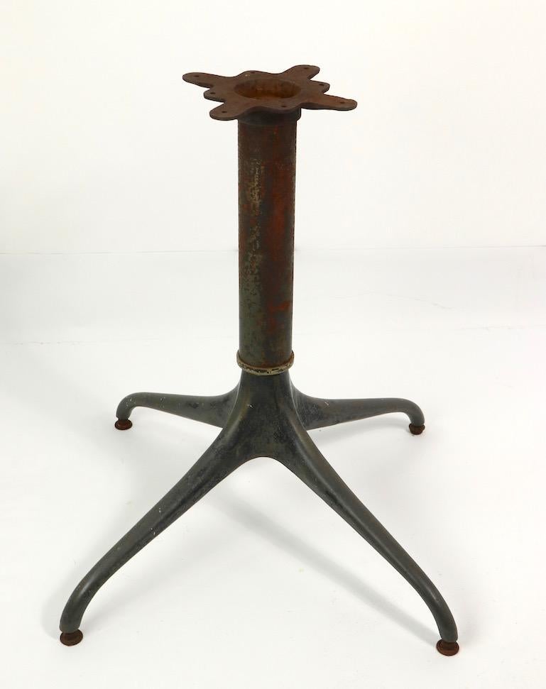 Stylish cast iron and steel cafe table base having four curvilinear legs which emanate from the tubular center post. The base is heavy, solid and sturdy, the finish shows considerable cosmetic wear to finish, please see images. The base is marked by