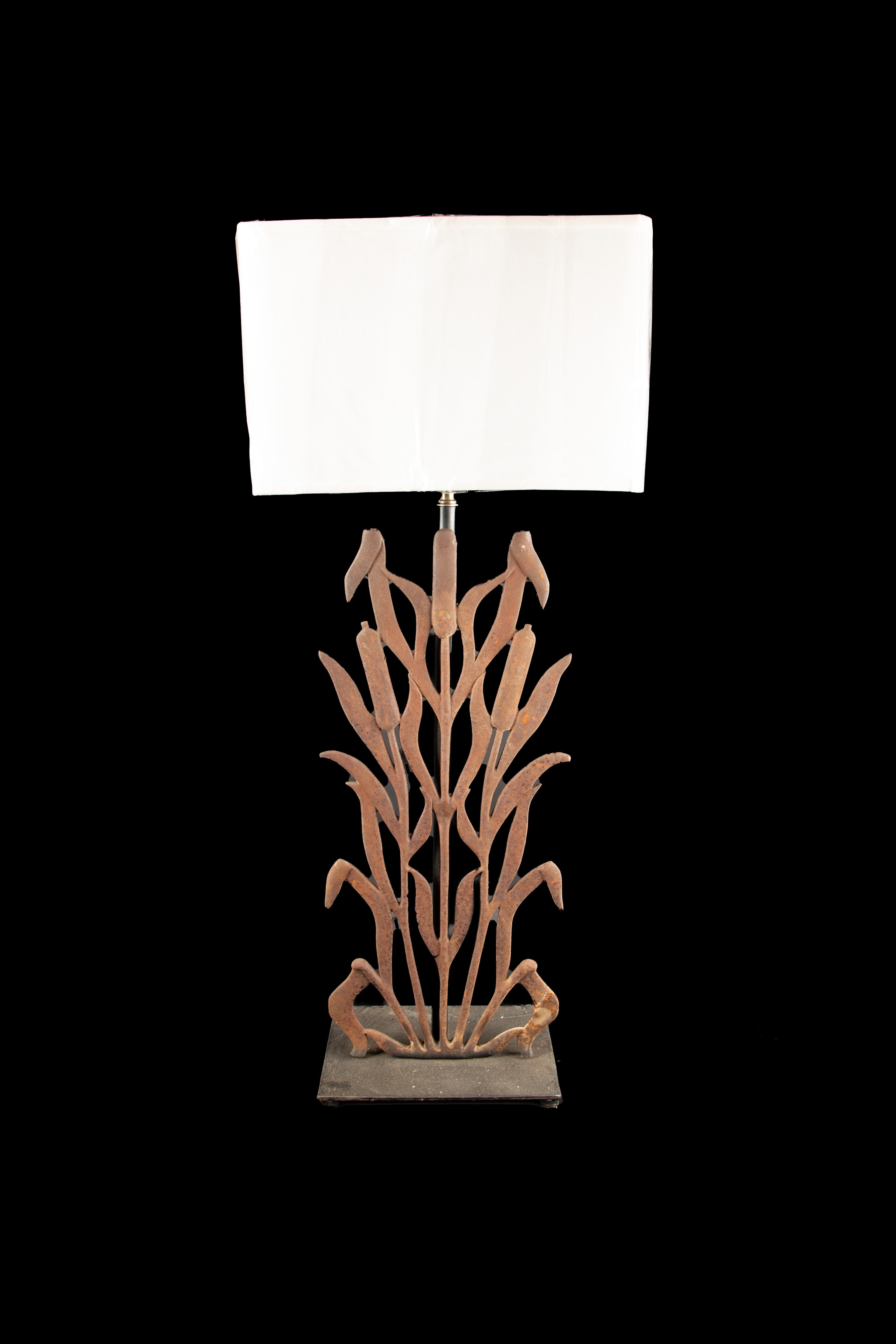 The Cast Iron Cattail Lamp Pair offers a striking blend of history and artistry, showcasing the transformation of repurposed vintage architectural railing/gates into stunning lamps that exude timeless beauty. These lamps serve as captivating relics,