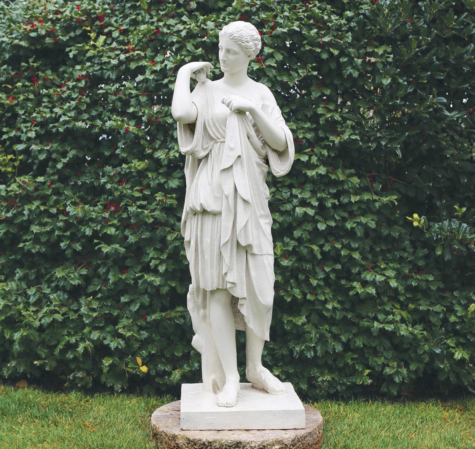 Une belle figure en fonte de Diana de Gabii, la déesse debout à côté d'un tronc d'arbre et drapée de robes, sur sa base intégrale.

Ce modèle de Diane est l'une des nombreuses répliques dérivées de l'œuvre romaine mise au jour par Gavin Hamilton en