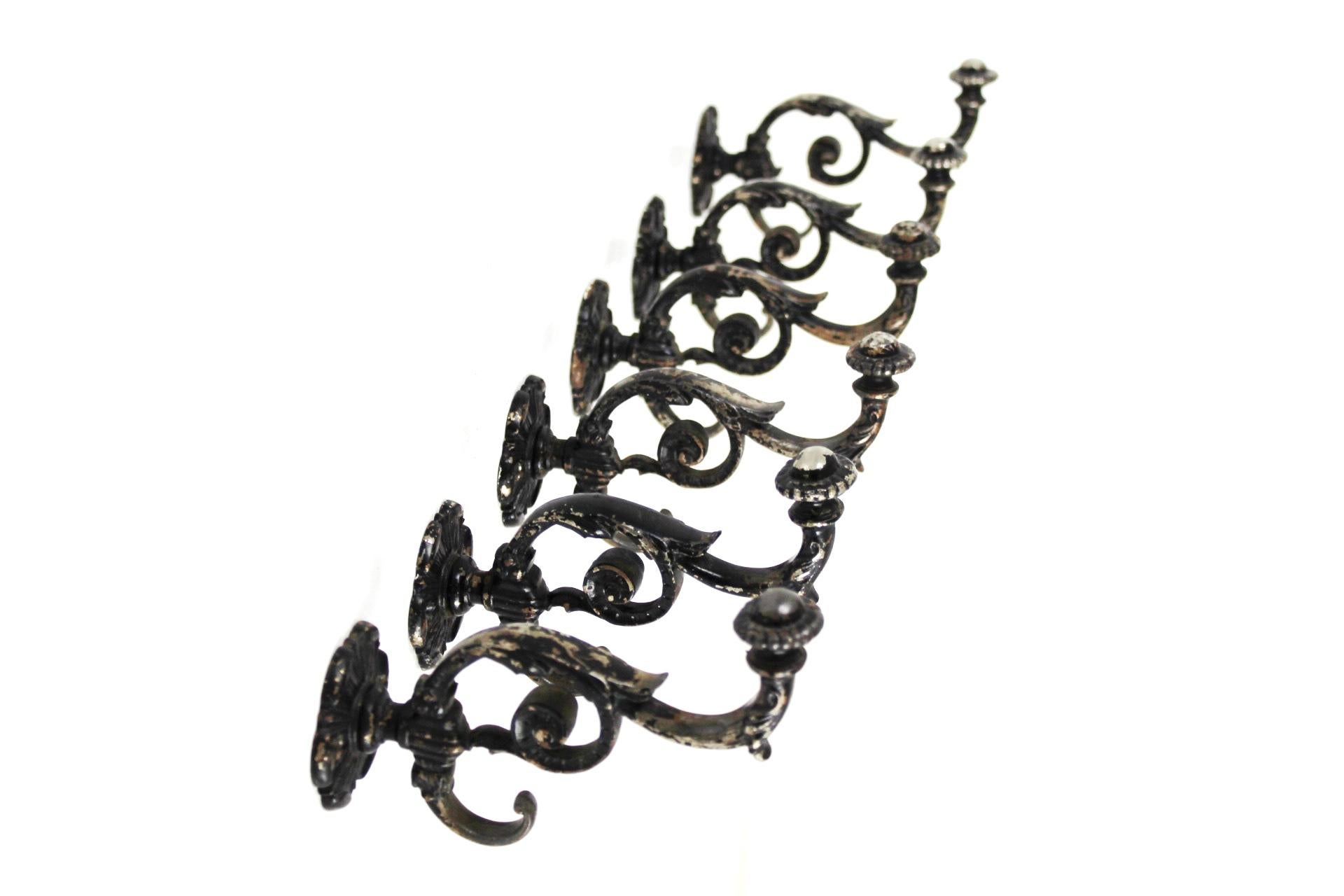 This set of 6 heavy solid cast iron coat hooks is partially blackened.