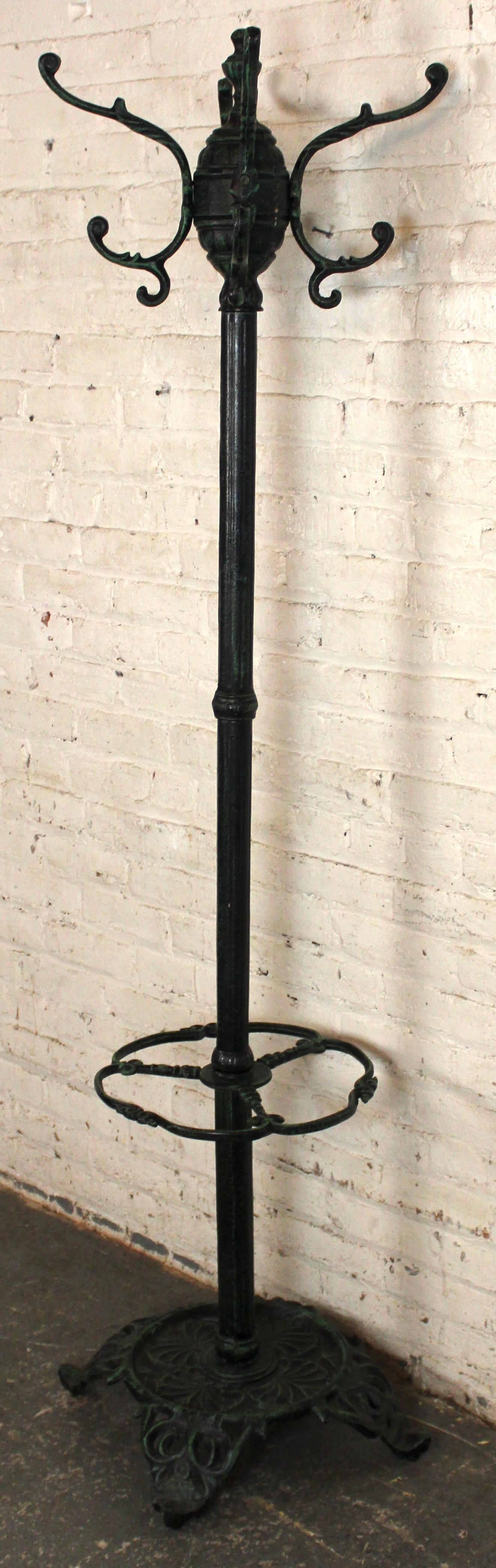 Elegante e funzionale appendiabiti in ferro battuto con portaombrelli integrato, realizzato in stile antico. Caratterizzato da una resistente finitura verde patinata, questo pezzo aggiunge fascino vintage e praticità di stoccaggio a qualsiasi