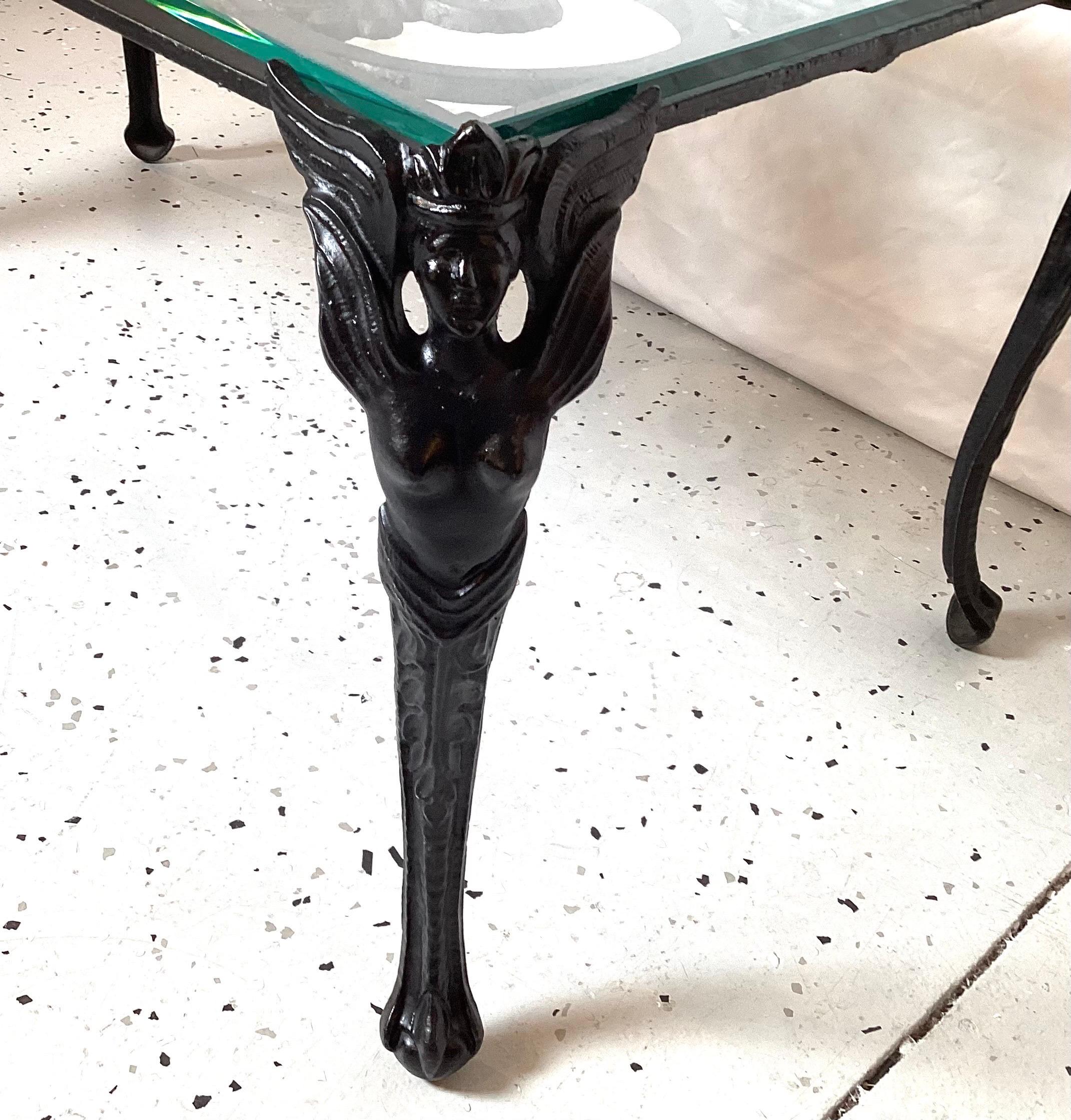 Cast iron coffee table with glass top and winged woman on corners. Wonderful condition.