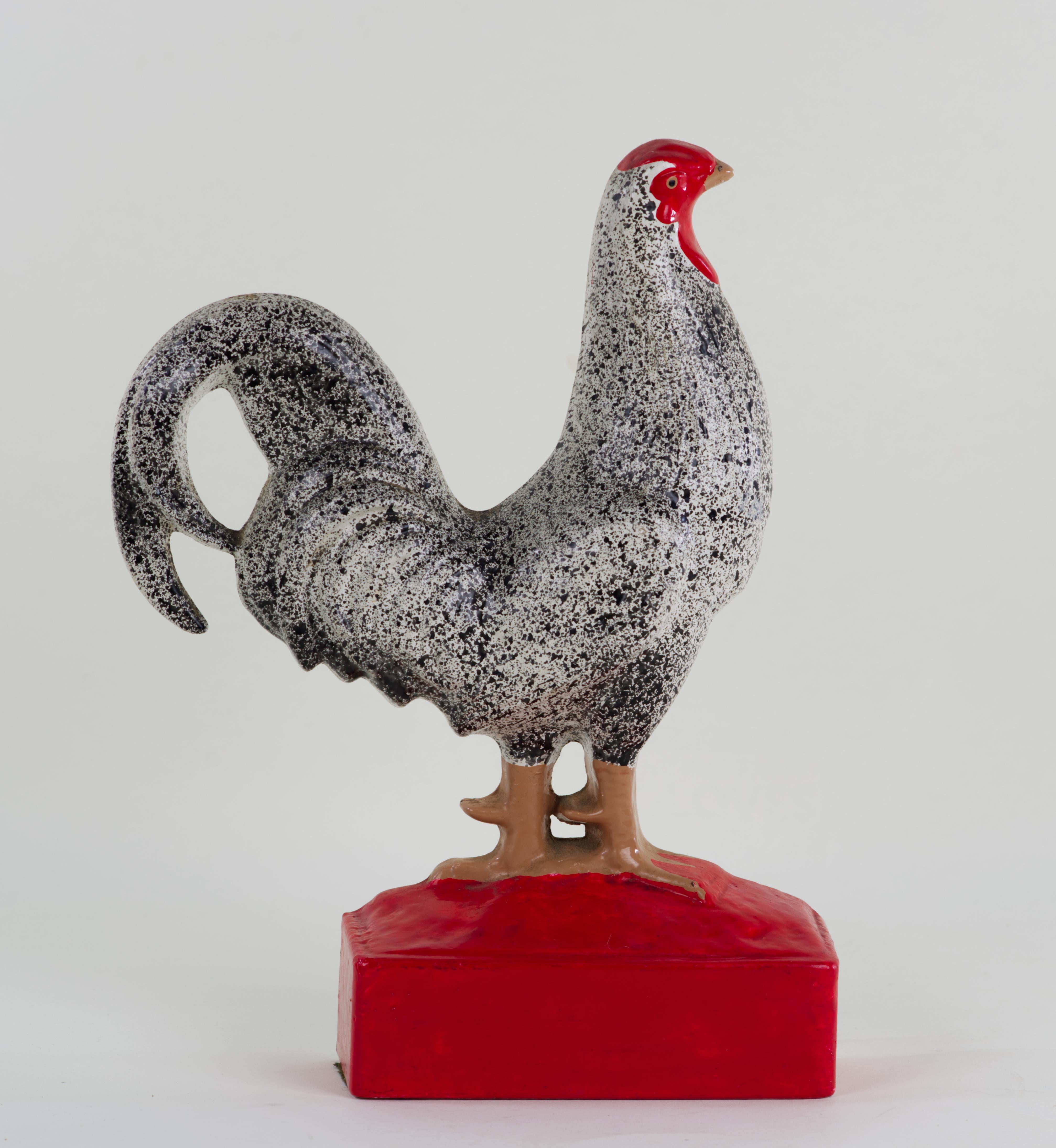  Cast iron enameled chicken figurine can be used as a doorstop or as a decor piece. The piece is highly detailed with individual tail and wings feathers and head structure molded separately. The body of the chicken is painted with black and grey