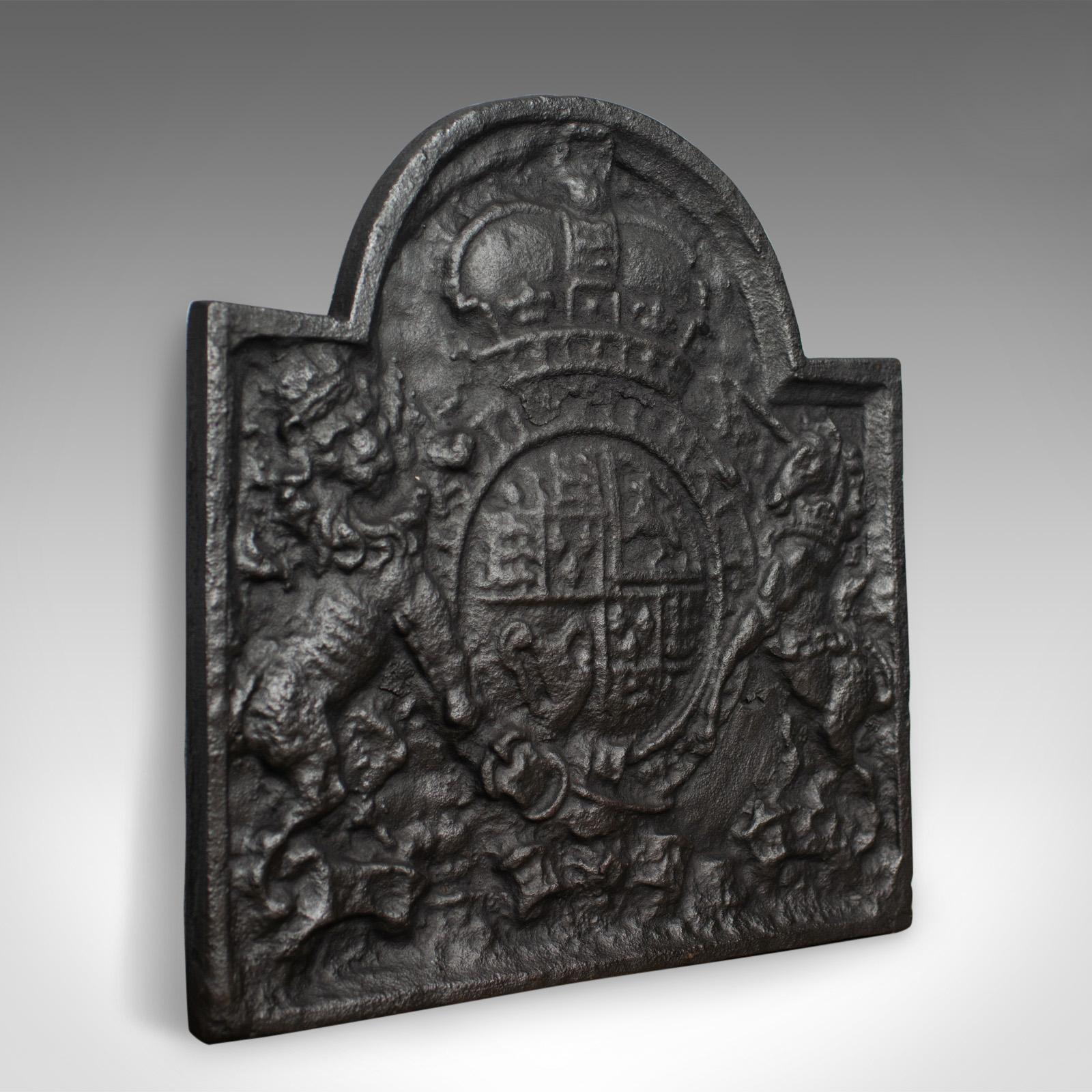 This is a cast iron fire back displaying the royal crest. A heavy fire plate to back a fireplace and retain heat. A revival casting crafted in the late 20th century.

Heavy fire back in cast iron with a graphite finish
Shaped top over oblong