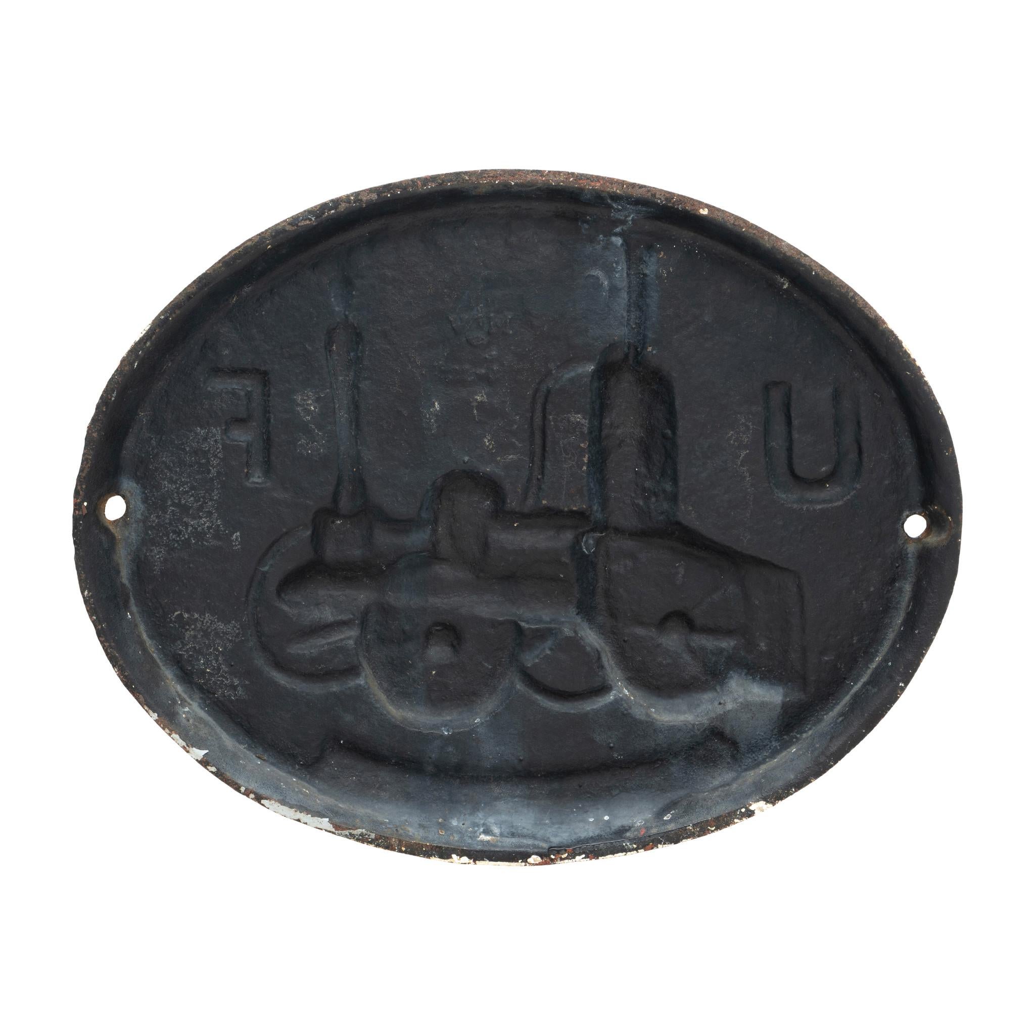 Painted cast iron horizontal fire marker with a fire engine and initials 
