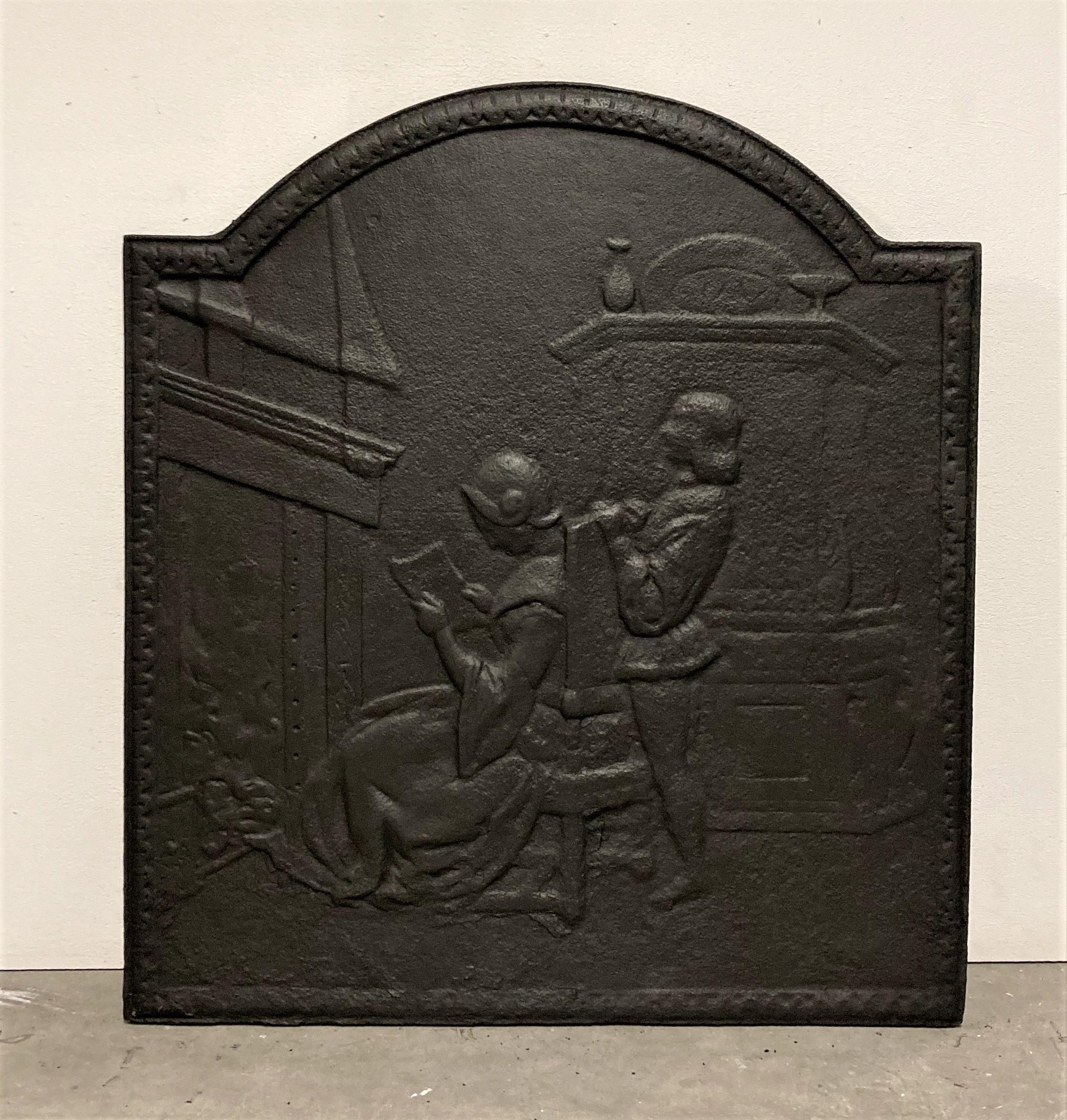 Nice sized 19th century cast iron fireback.
Showing a nice family scene, man standing behind his wife who is reading in front of the hearth.
Lovely warm welcoming and detailed fireback.

Great condition can be used in a real fire.
Sold by