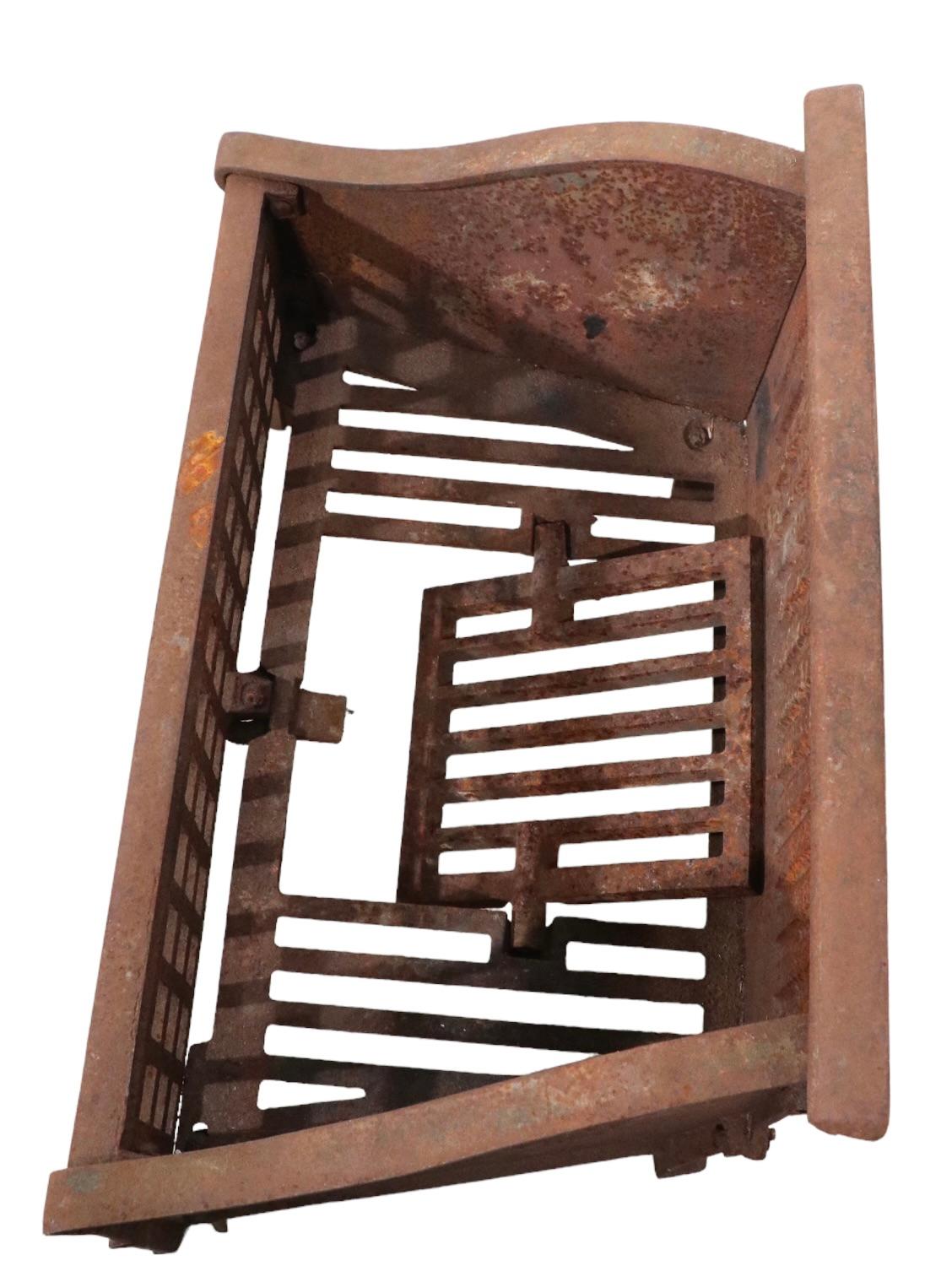 Cast iron fireplace interest grate, originally designed to hold coal, but will also work for wood. This example is in good, original, estate condition, it shows all over surface rust, but no structural damage, rust, breaks, or repairs. Made by The