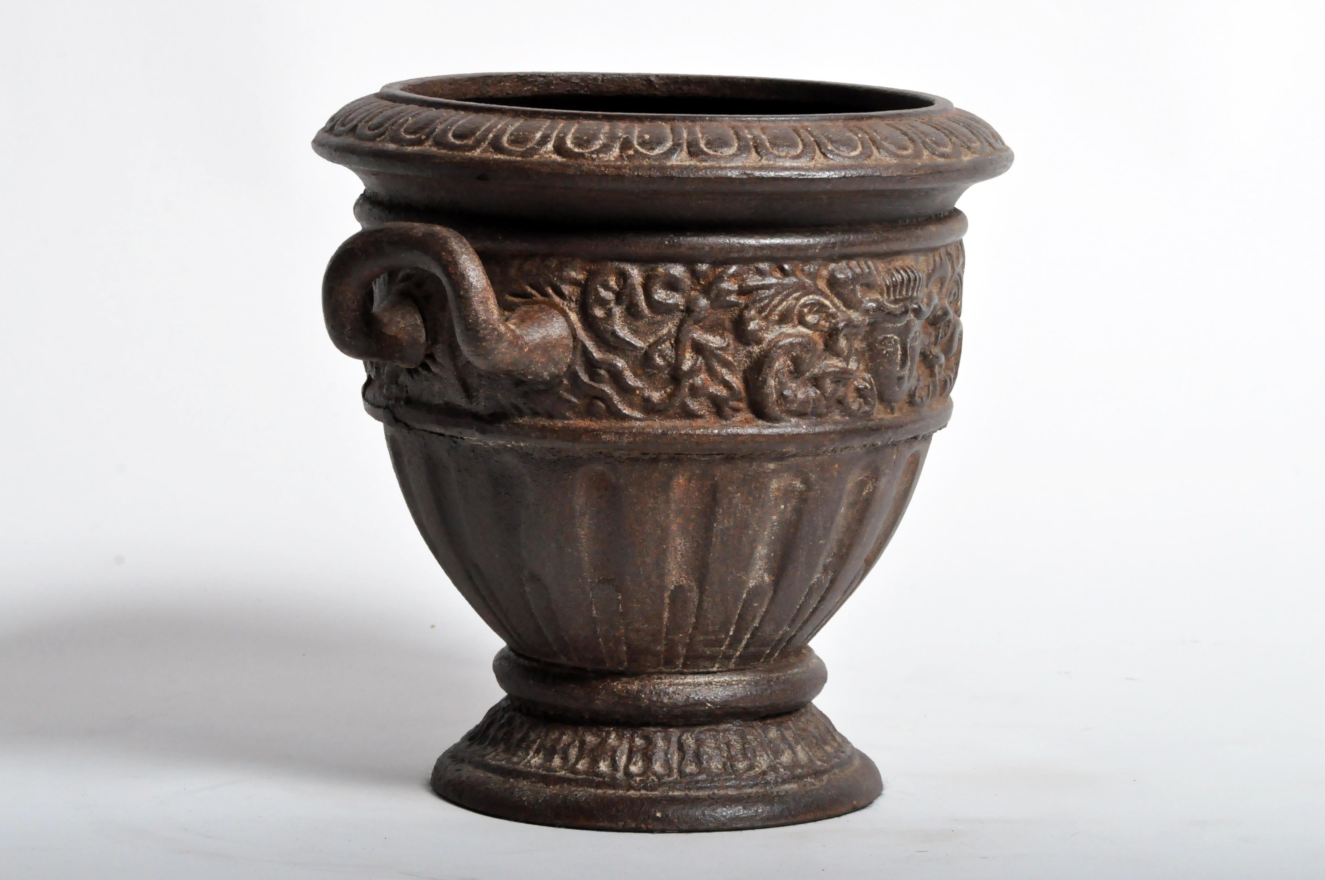 A flower pot from India, made from cast iron, circa 1960. The pot features two handles and its original patina.