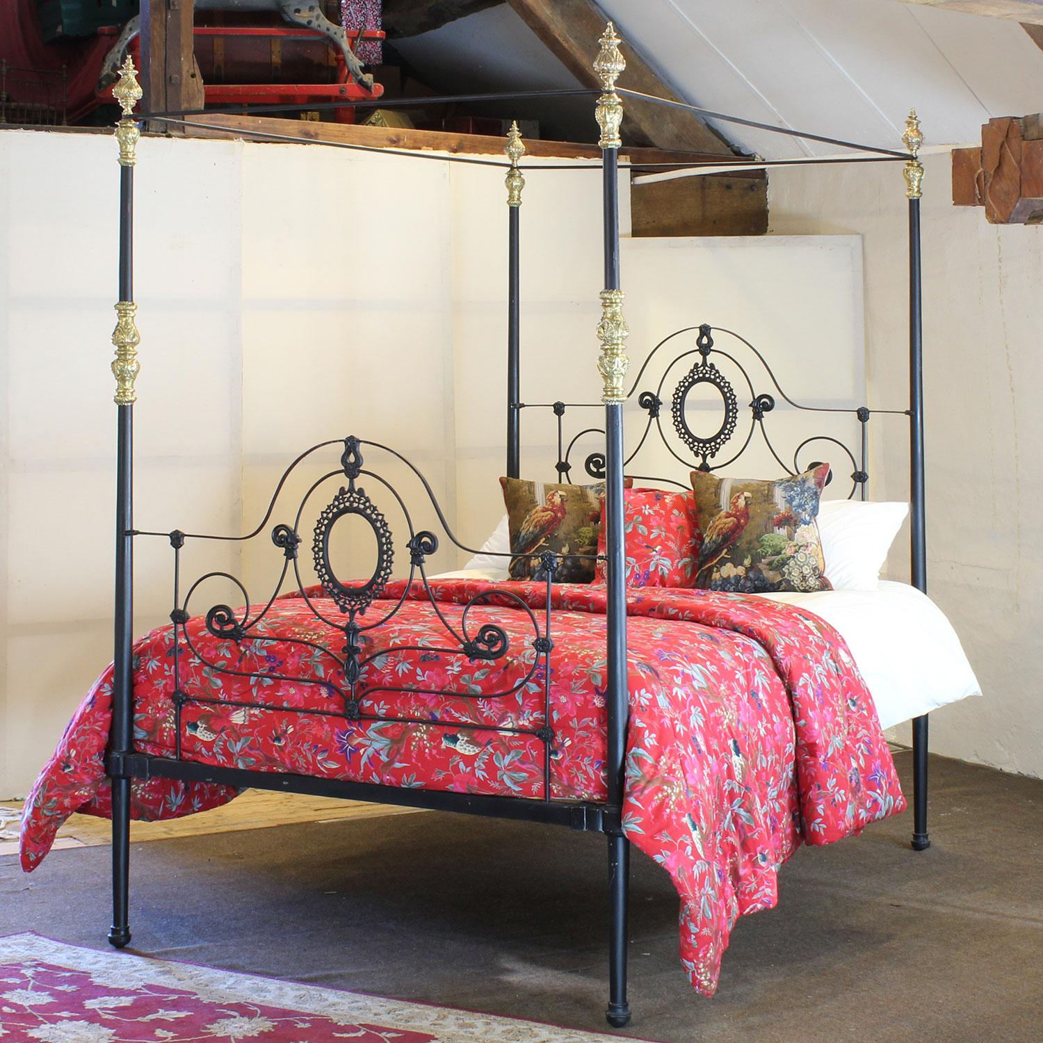 A 5ft wide cast iron antique four poster bed finished in black with ornate castings and original brass decoration. 

This bed accepts a British King Size or US Queen Size (5ft or 150cm wide) base and mattress set.

The price includes a firm bed base