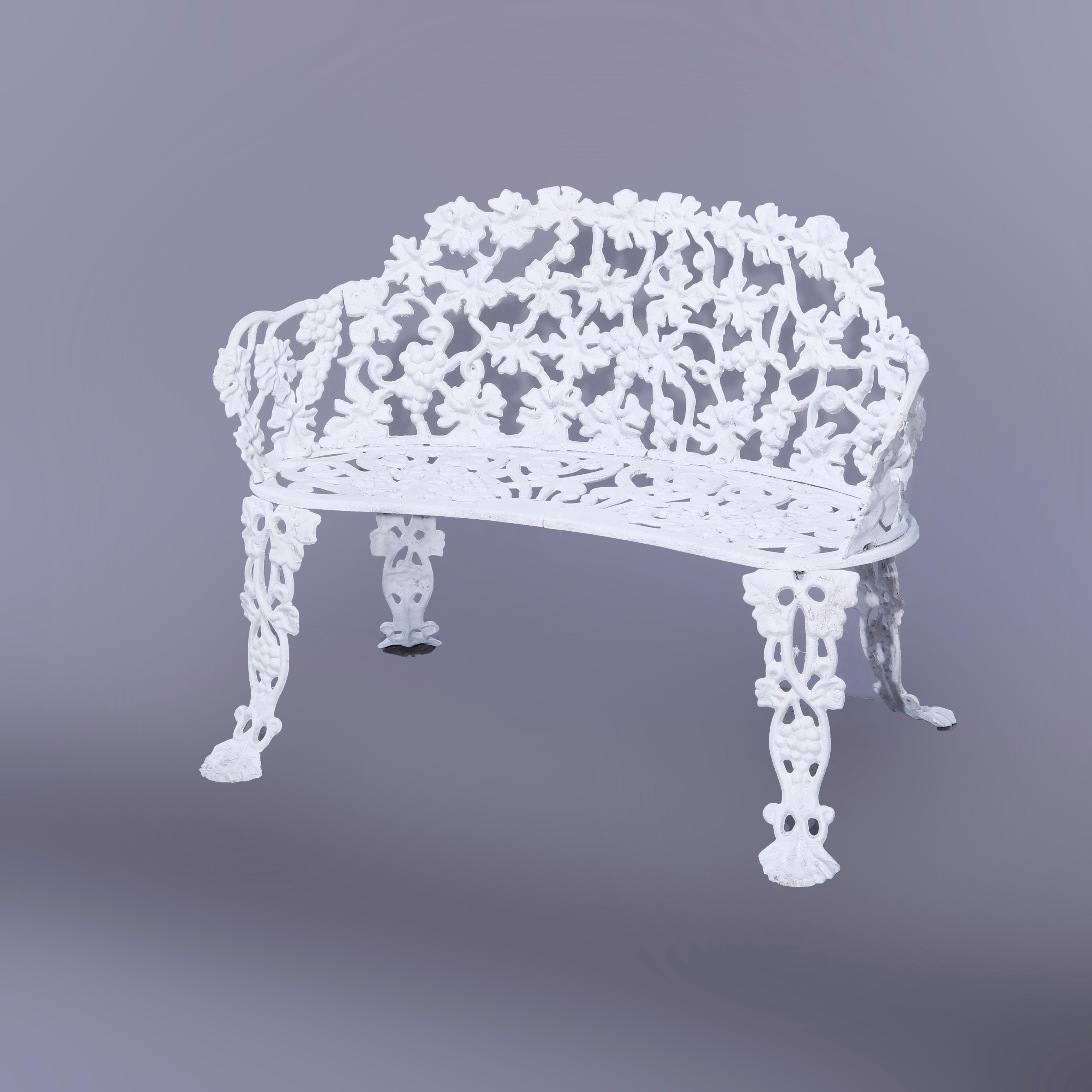 A garden bench offers cast iron construction in pierced grape leaf design, white painted, 20th century

Measures - 28'' H x 38.5'' W x 25.5'' D; seat height 14.25