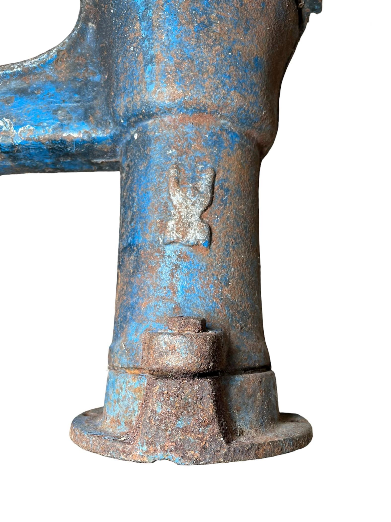 This is a Hand Water Pump. It depicts a cast iron hand water pump that was originally painted blue and it is hallmarked at the top Sicvumi or Sicvuni.