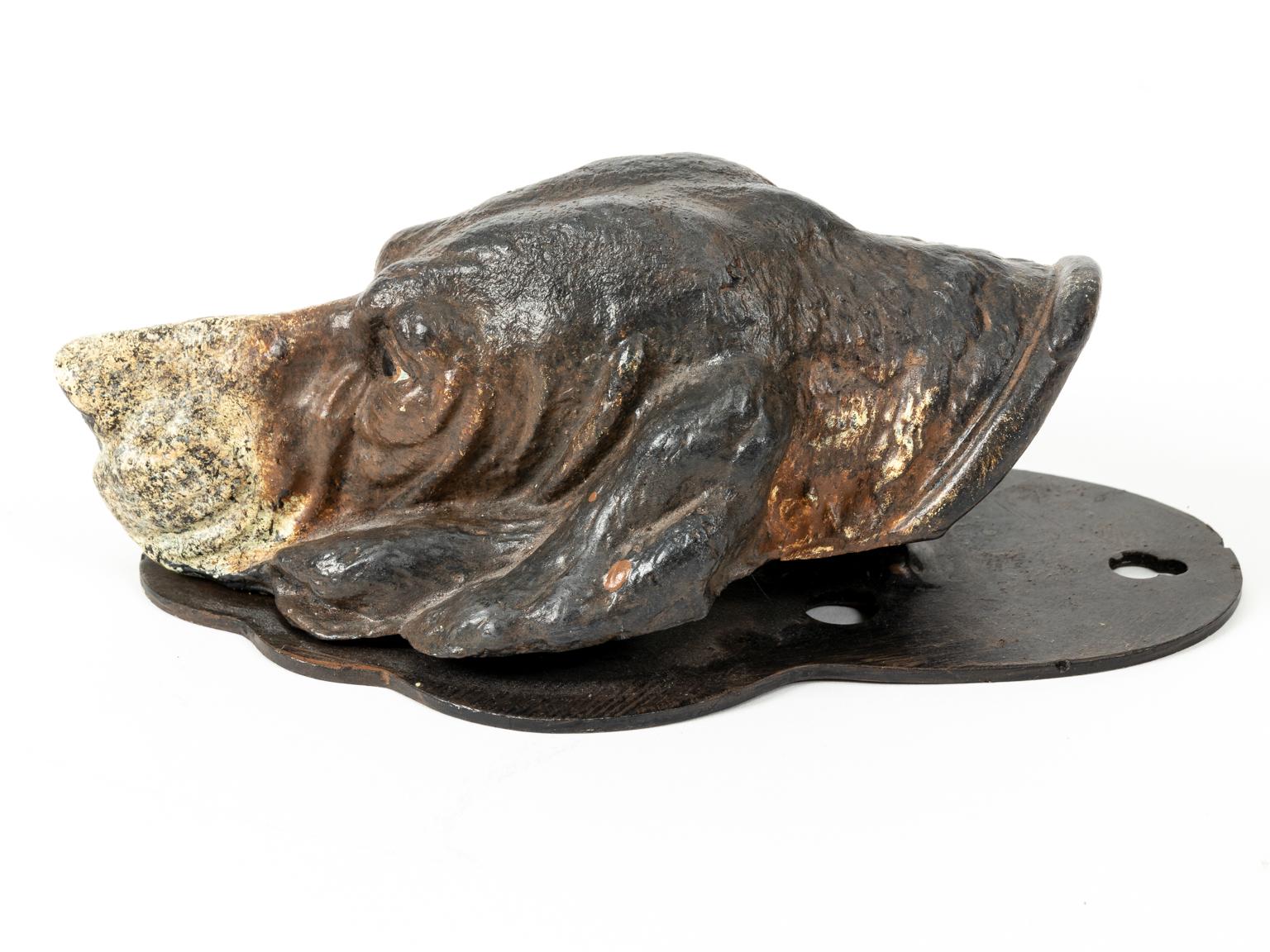 Circa early 20th century desk wall art clip or bill holder. The piece is composed of cast iron in the shape of a hound dog with original patina and no structural damage. Particular decorative detail includes painted eyes and nose. Please note wear