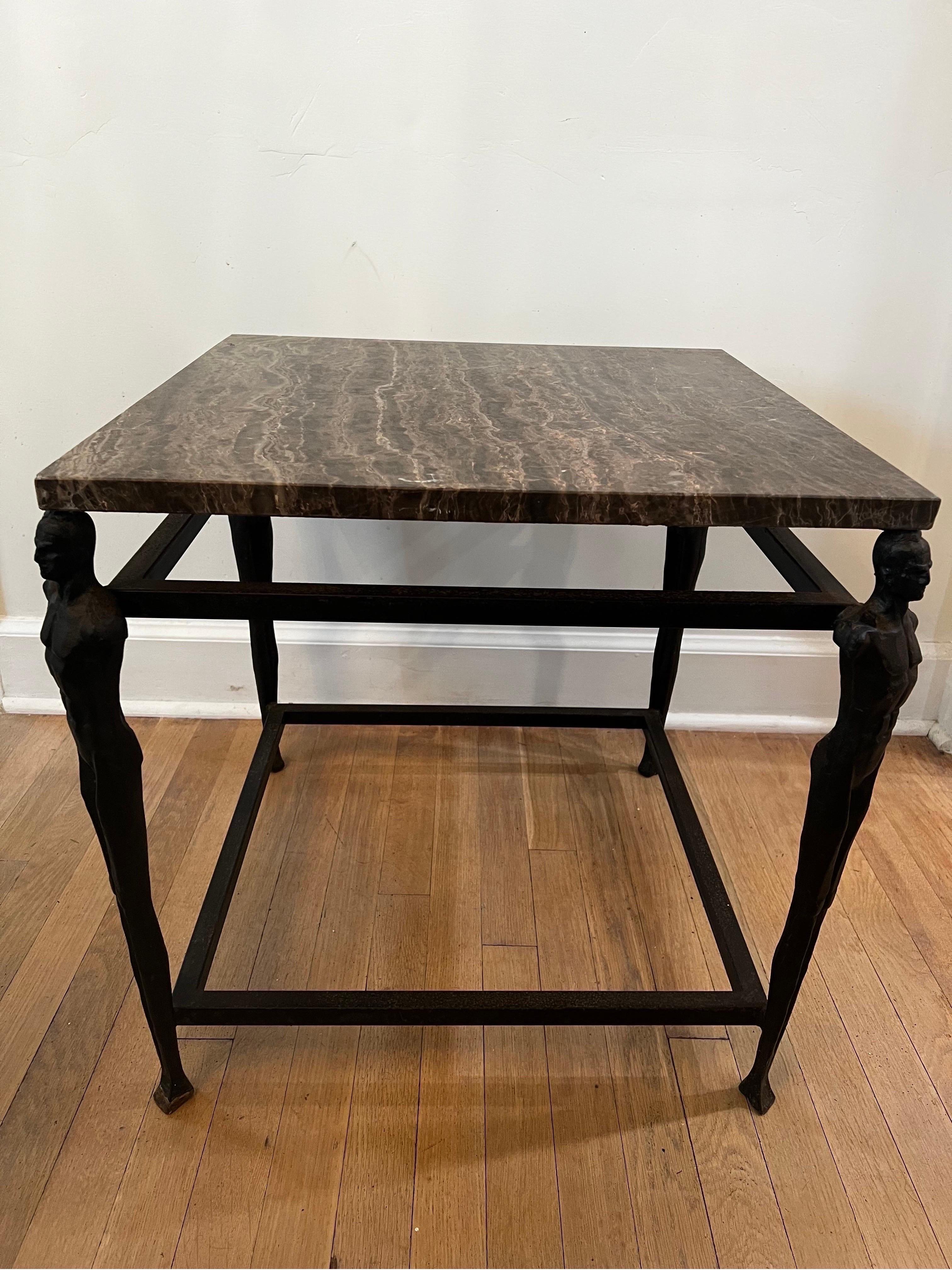 Unique iron side table with 4 figurative/male body figurines at each leg in the style of Giacometti. 
Top is dark rustic colored marble but does have heavy scratching and should probably be replaced.

Table is solid and heavy.  Bronze colored Iron
