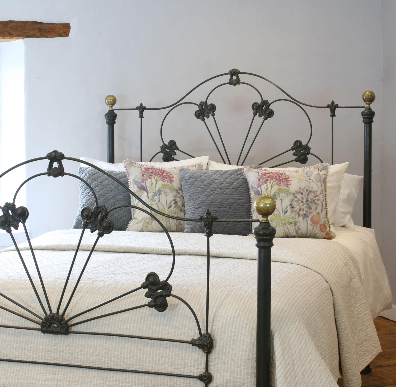 A mid-Victorian cast iron bedstead, finished in dark green with gold highlights on the castings. This bed has a hoops design with decorative castings on the head and foot boards. The bed can repainted in any color of your choice, if desired.