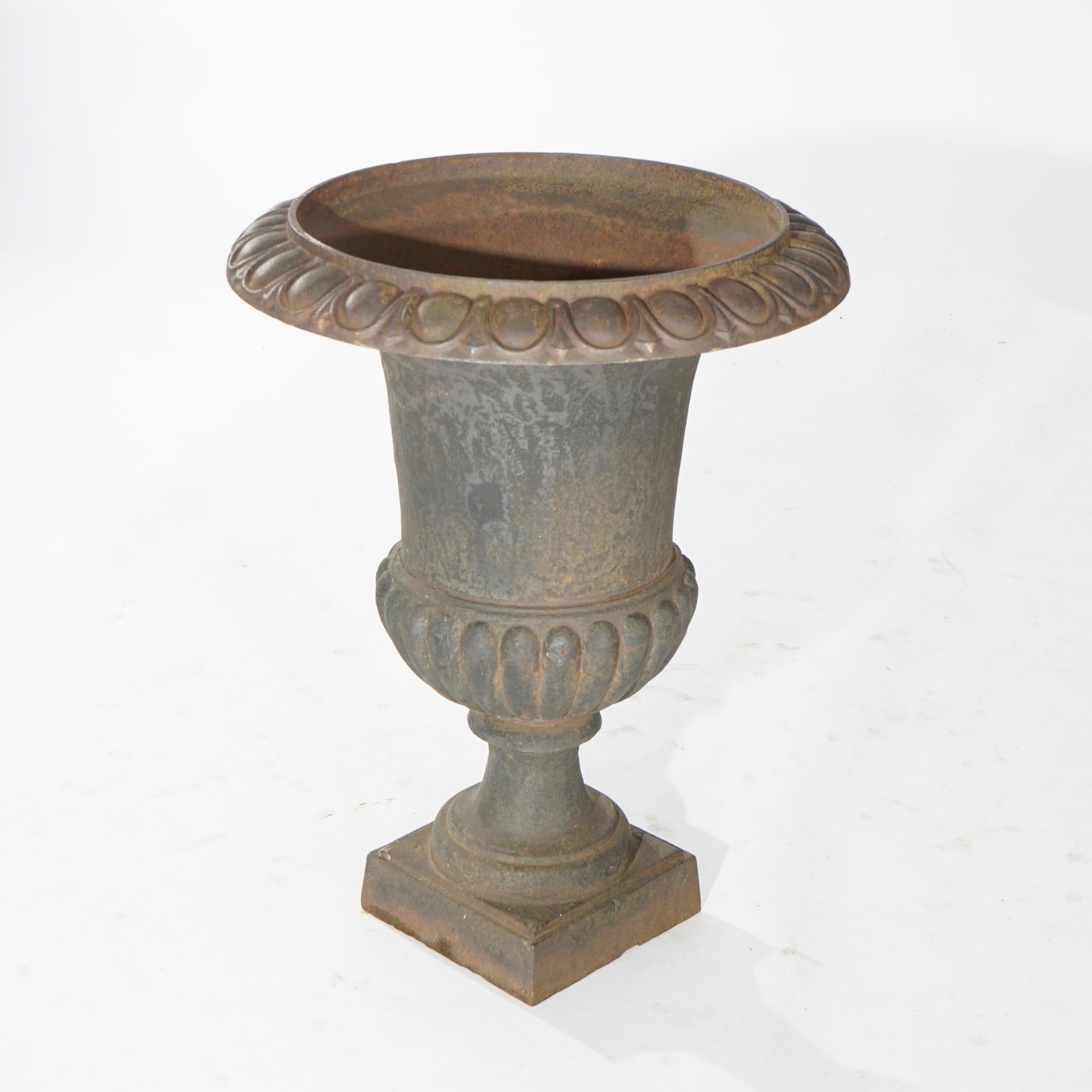 A Neoclassical style garden urn offers cast iron construction with egg and dart rim over planter with melon bowl and raised on pedestal base, 20th century

Measures- 24.75''H x 18.5''W x 18.5''D