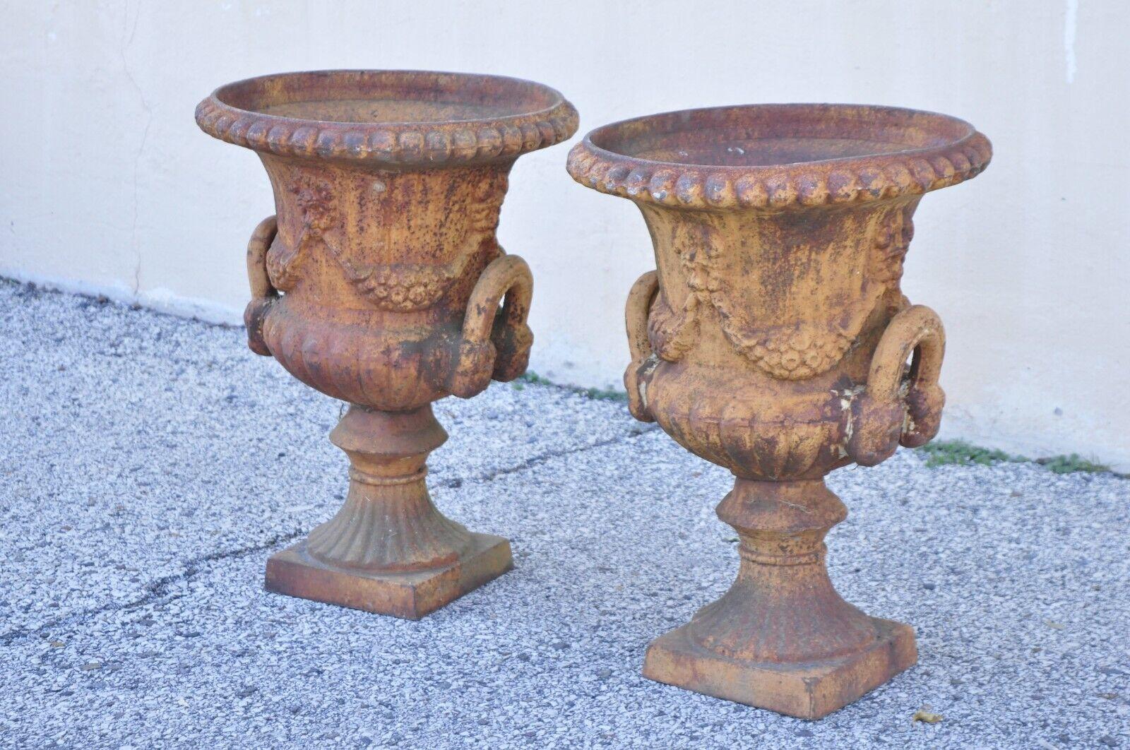 Cast Iron Neoclassical Style Figural Twin Handle Urn Garden Planter Pot - a Pair. Item features a weathered finish, figural twin handles, great style and form. Circa Late 20th Century. Measurements: 23