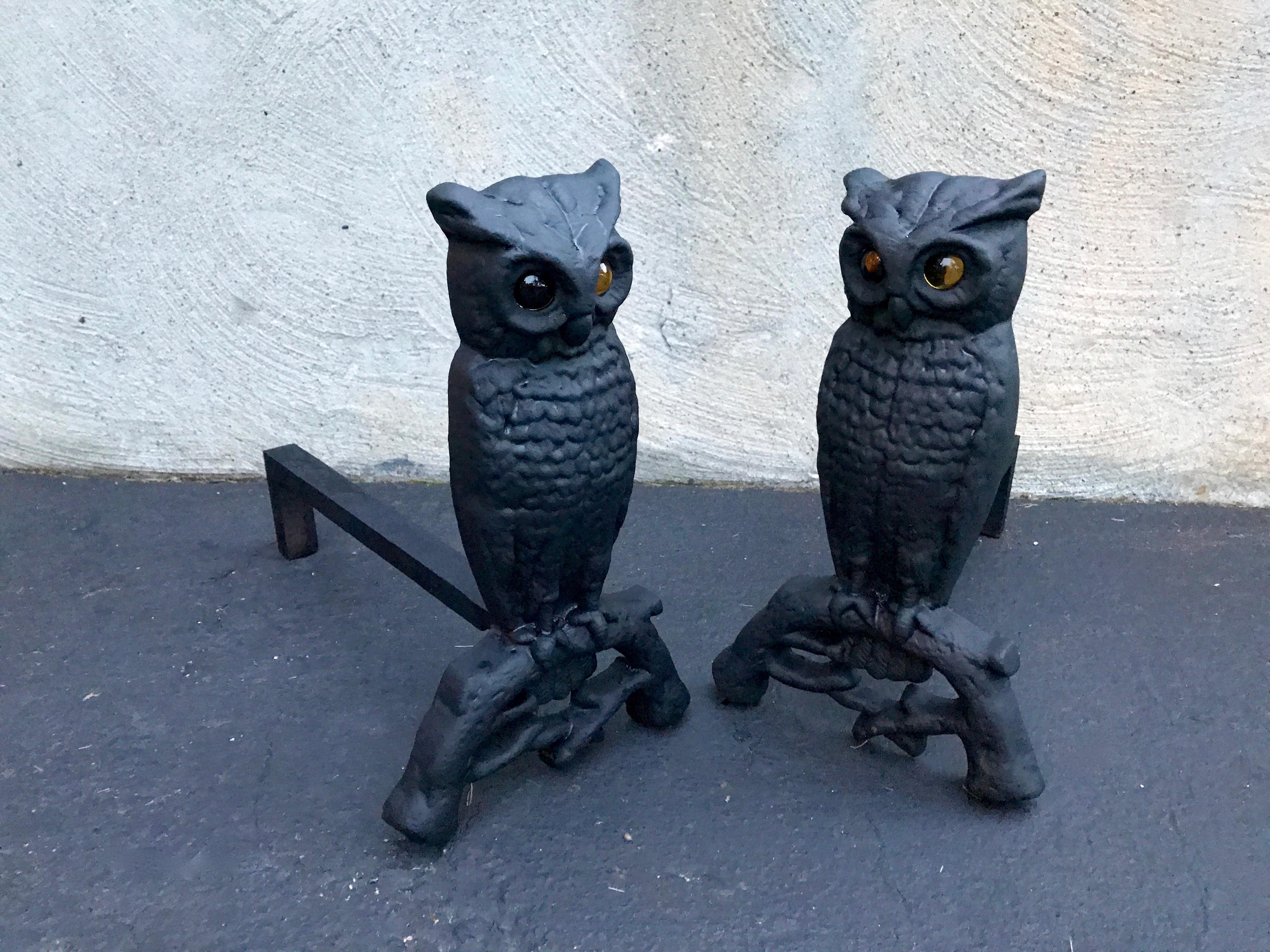 Cast iron owl form andirons with amber glass eyes through which the fire glows. These were likely made by the Howes foundry of Boston, Massachusetts around the turn of the century, 1900. The glass eyes have no cracks or breaks. The Owls and Fire