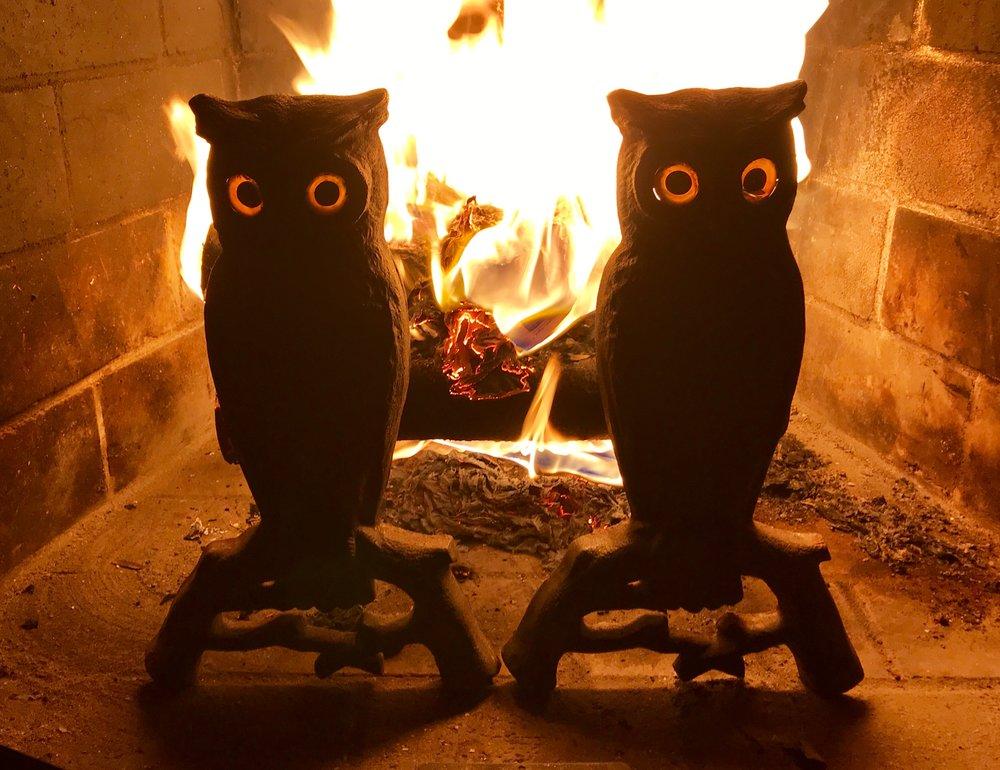 Cast iron owl form andirons with glass eyes through which the fire glows, late 19th century, (1890). New Hampshire. The glass eyes are in excellent condition with no cracks. Some patina on the front, but very good condition for the age and not