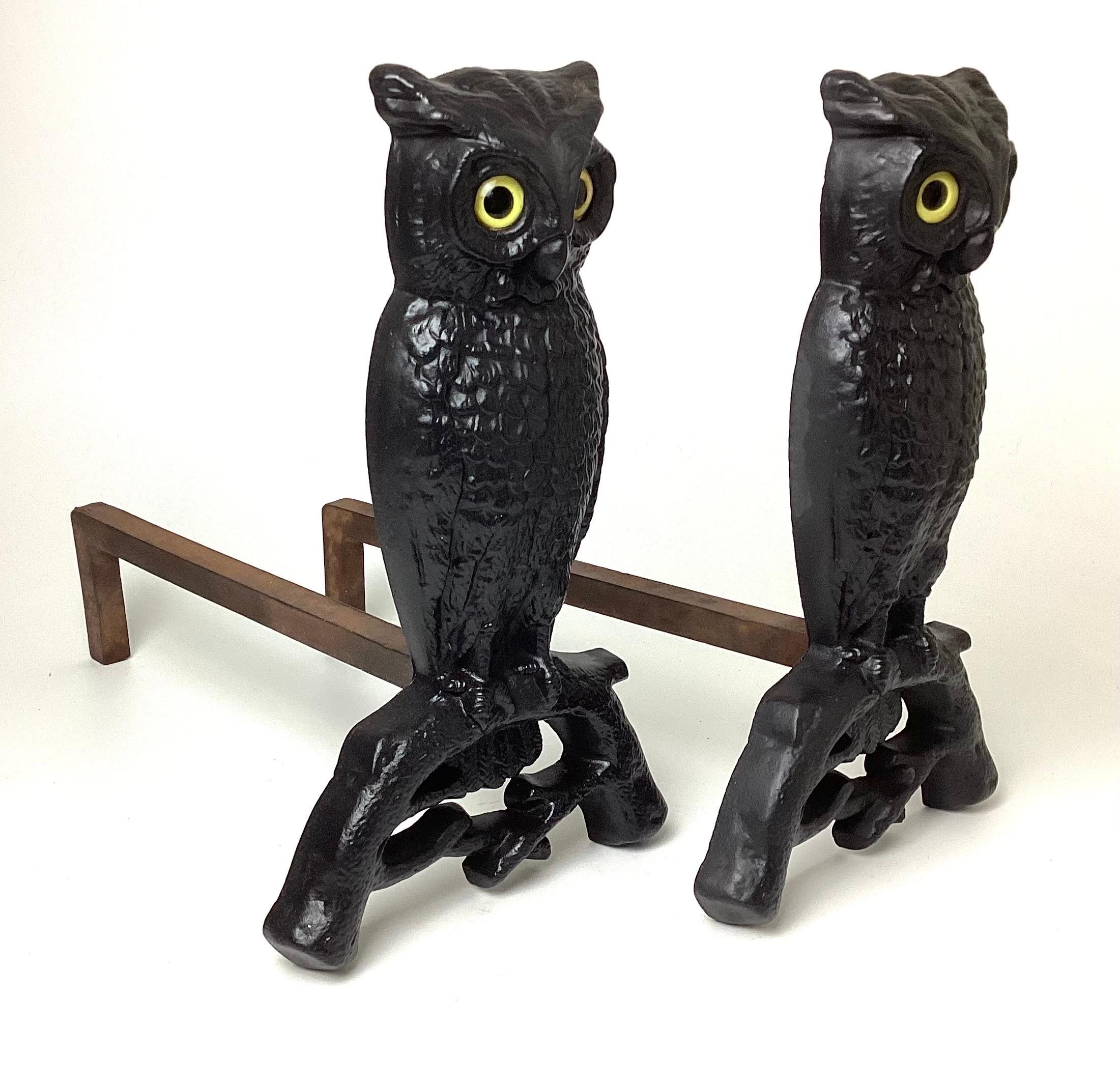 Cast Iron Owl Andirons with Glass Eyes from the early 20th century. Some minor surface rust. Eyes glow with light behind. Log dogs will be removed for shipping. Each dog is 14