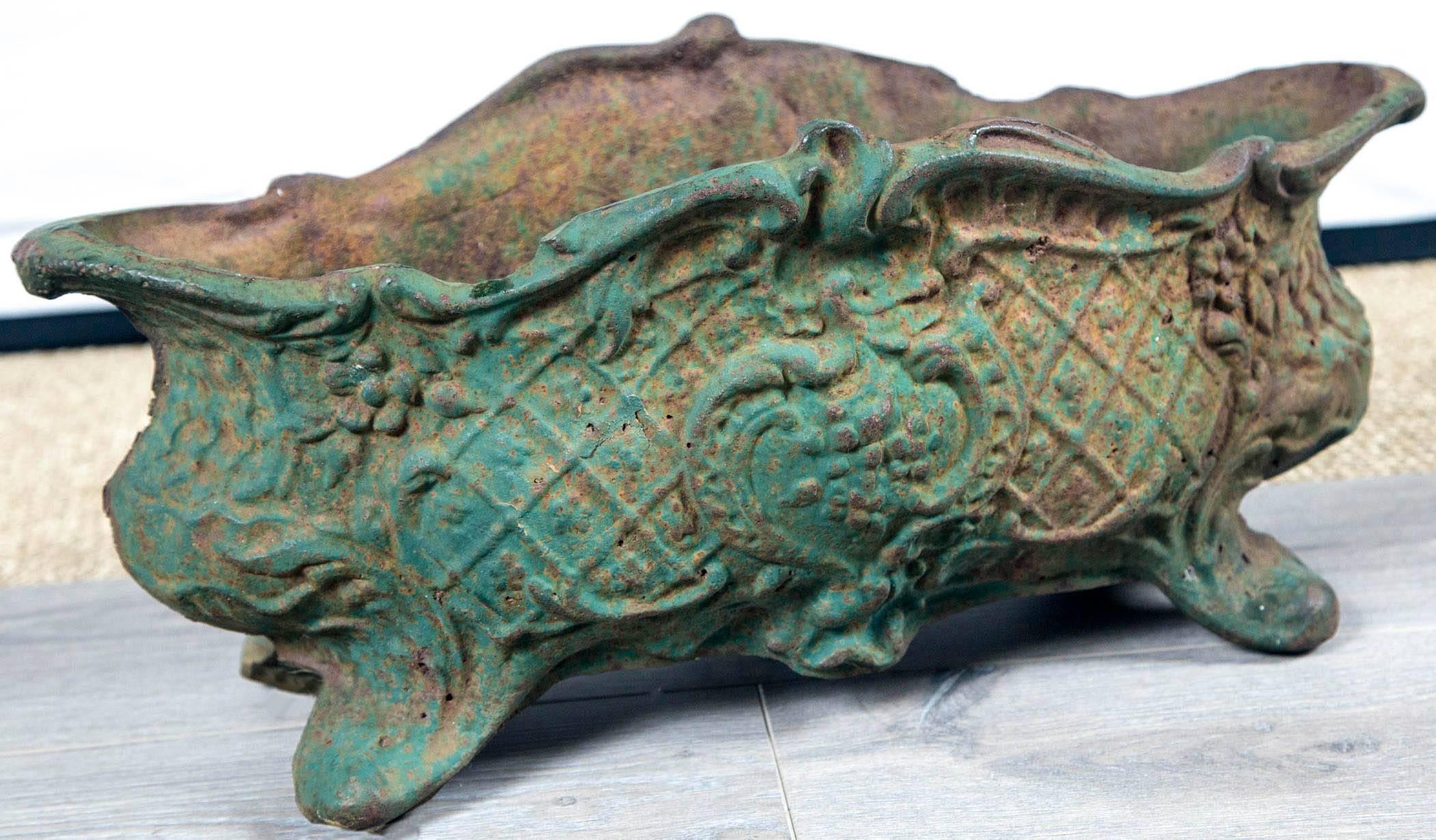 Jardinière en fonte:: France:: vers 1900. Merveilleuse forme oblongue avec sommet à volutes. Motif général détaillé de fleurs et de treillis. Surface peinte en vert vieilli.