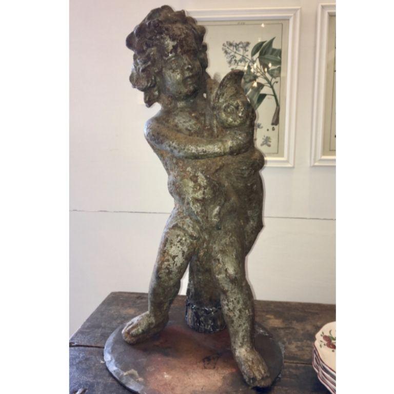 18th century cast iron putti and dolphin fountain, with a custom made base designed to allow use as a sculpture indoors or out.  This has a clear passage from the base to the mouth of the fish so can easily be returned to its function as a fountain