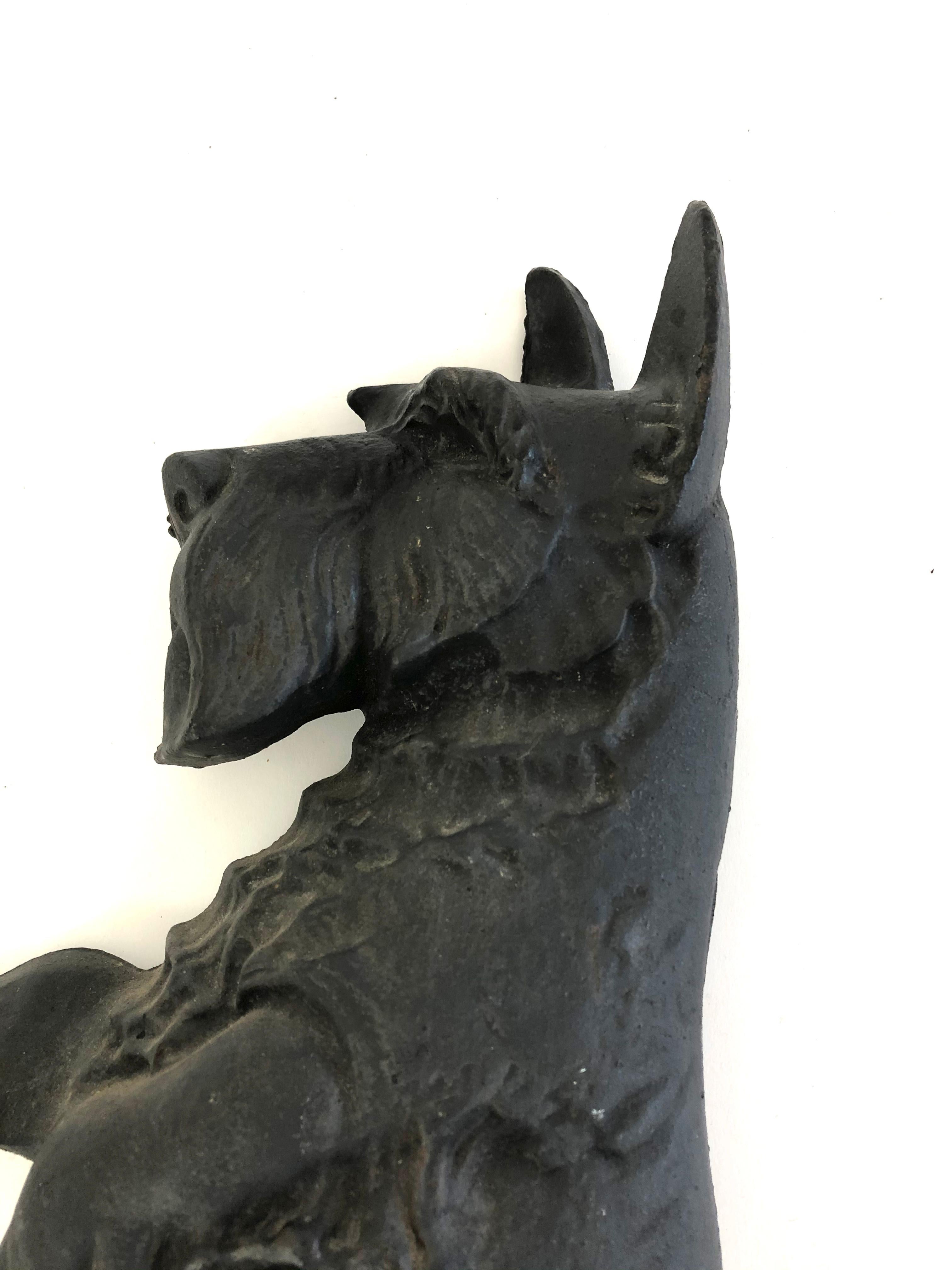 A well proportioned large black painted cast iron Scottish Terrier figure, modeled in relief and depicting an animated Scottie dog on its hind legs with two front paws extended. This would make for a wonderful wall or mantel decoration, as well as a