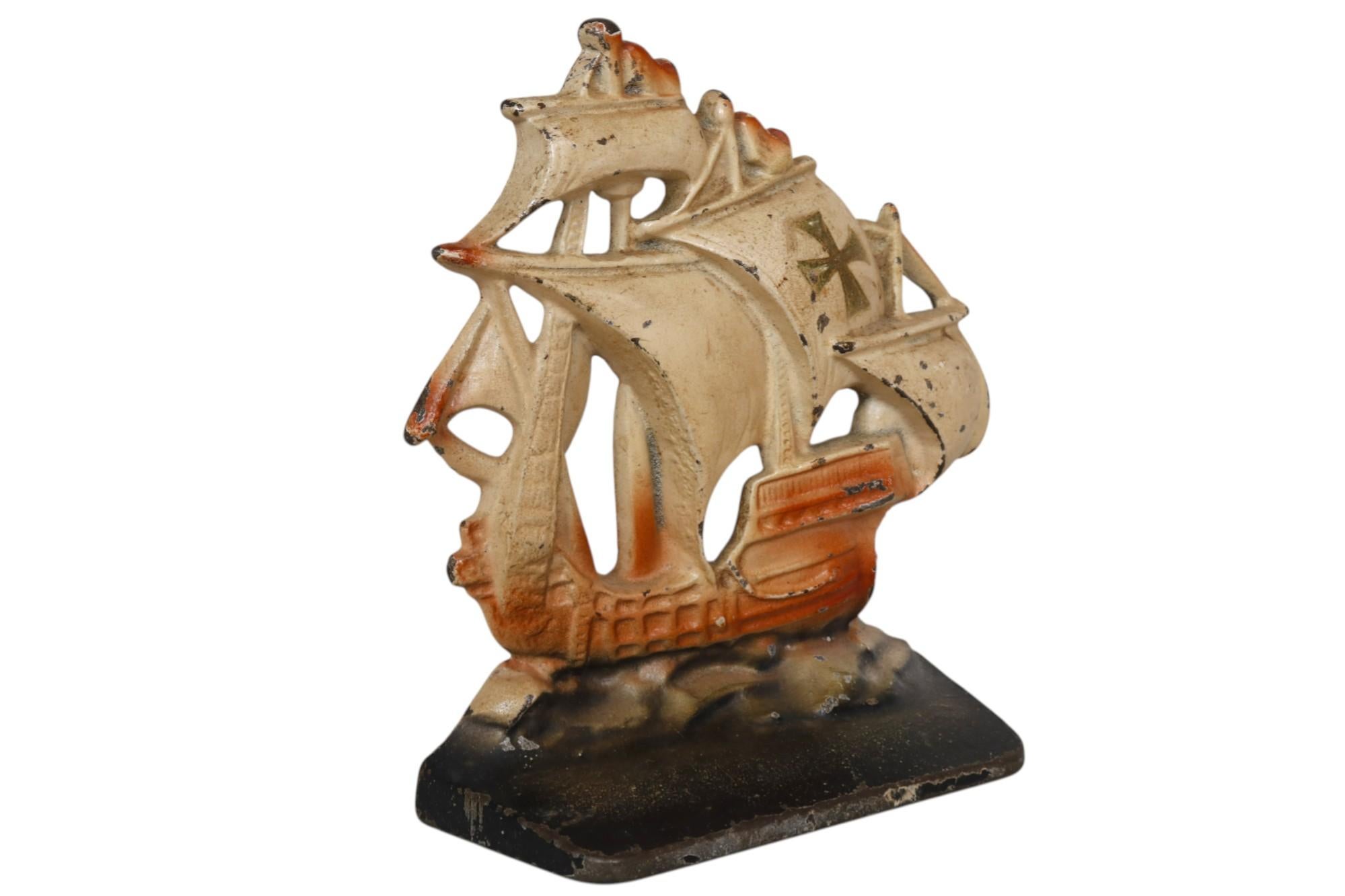 Par de sujetalibros de galeón español de hierro fundido pintado. Las velas de color crema están decoradas con la cruz, sobre barcos rojos y aguas oscuras y tormentosas. Dimensiones por sujetalibros.