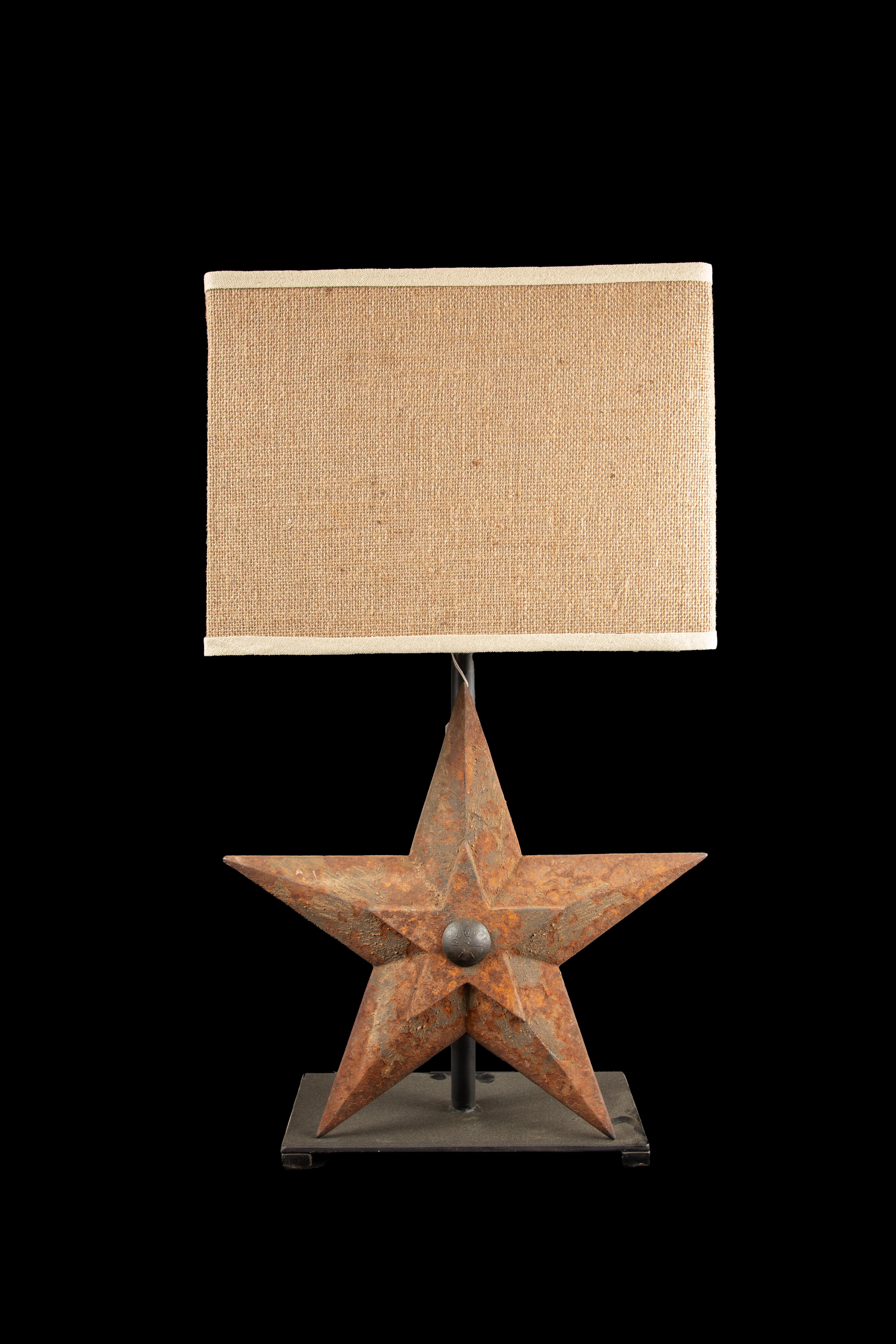 Cast Iron star lamp. Star was used as and architectural element for building and repurposed as a lamp. This fusion of form and function creates a conversation piece that not only illuminates a space but also pays homage to the past, infusing it with