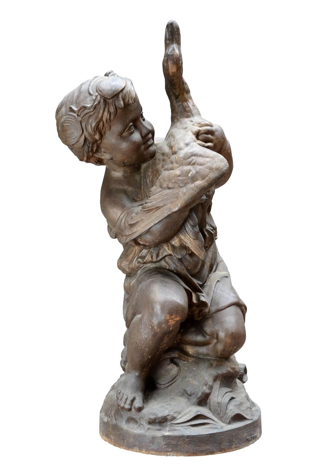 Dated from the 19th century, cast iron statue of the child and the duck after Mathurin Moreau (1822-1912) by the foundry of Val d'Osne. The statue represents a child kneeling in the middle of ferns enclosing a duck. The joyful expression of the boy