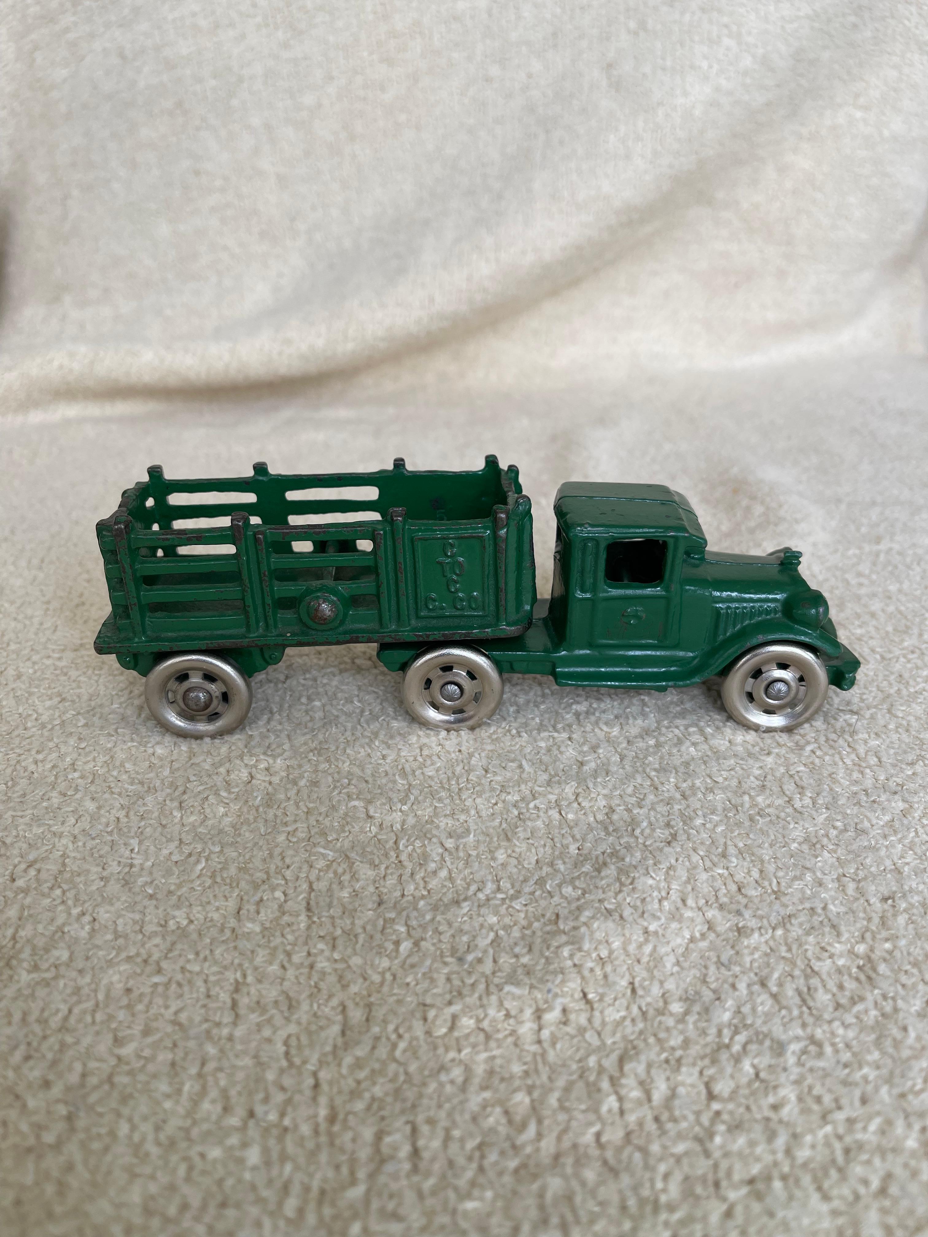  Ce magnifique camion est un bel exemple des merveilleux jouets en fonte fabriqués aux États-Unis dans la première moitié du XXe siècle. La peinture vert foncé et les roues en fer sont d'origine, et l'état de cette voiture est si difficile à